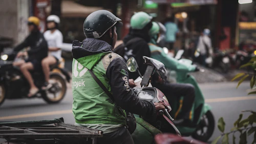 Livreur à moto en pleine circulation, illustrant les livraisons indépendantes Ozouri