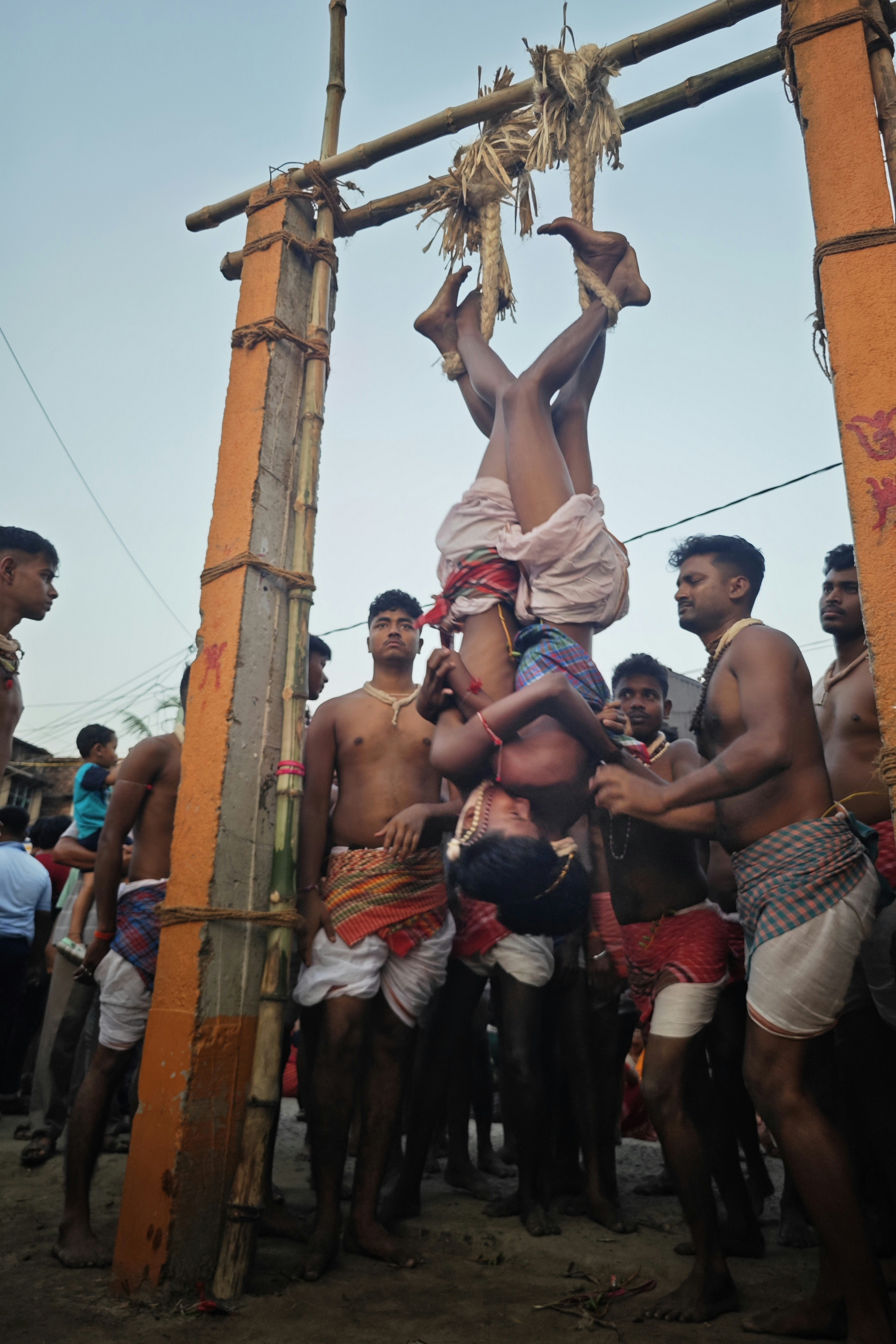 Hombres realizando una pirámide humana ritualística al revés.