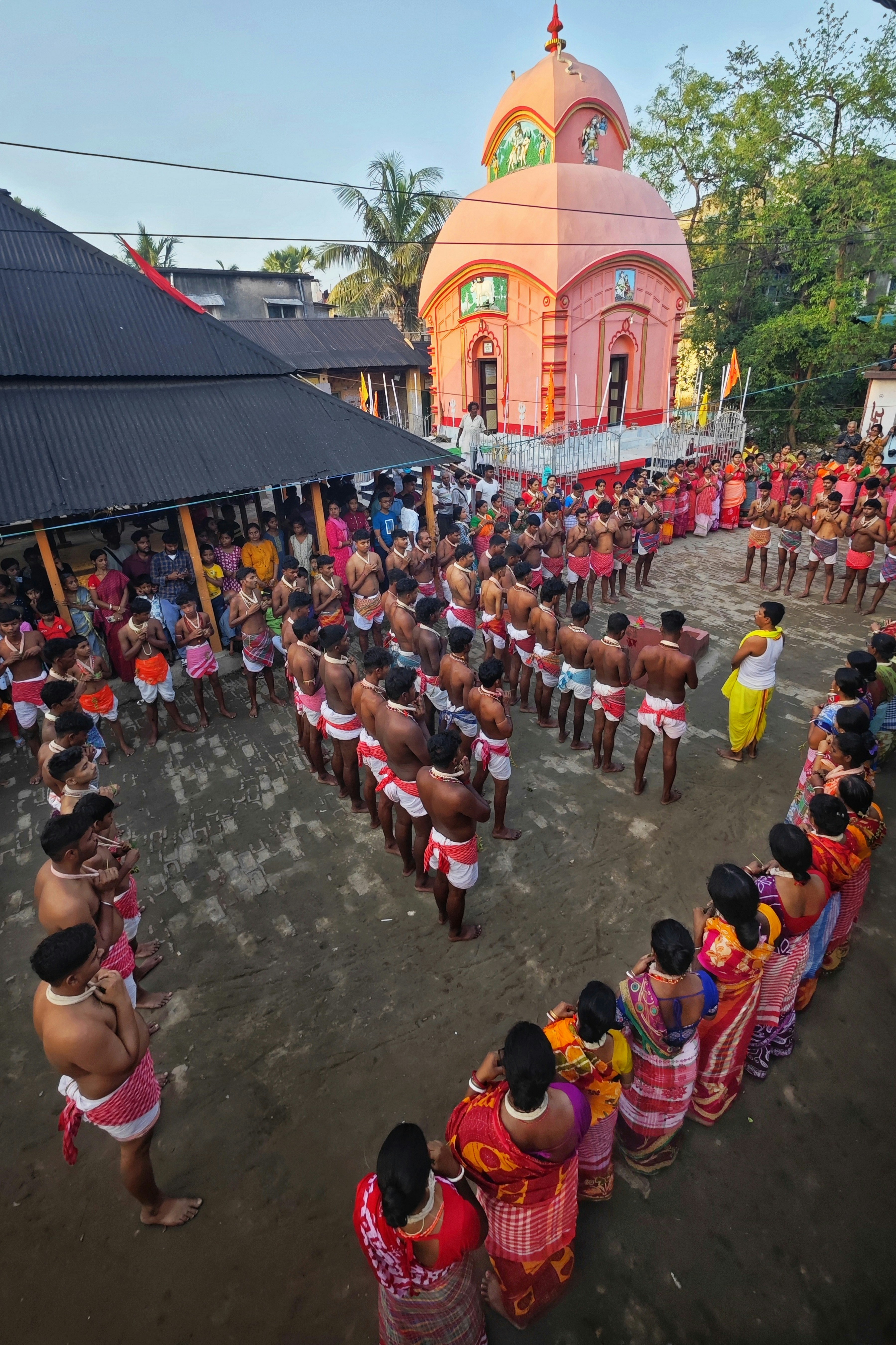 La gente se reunió para una ceremonia tradicional cerca de un templo rosa.