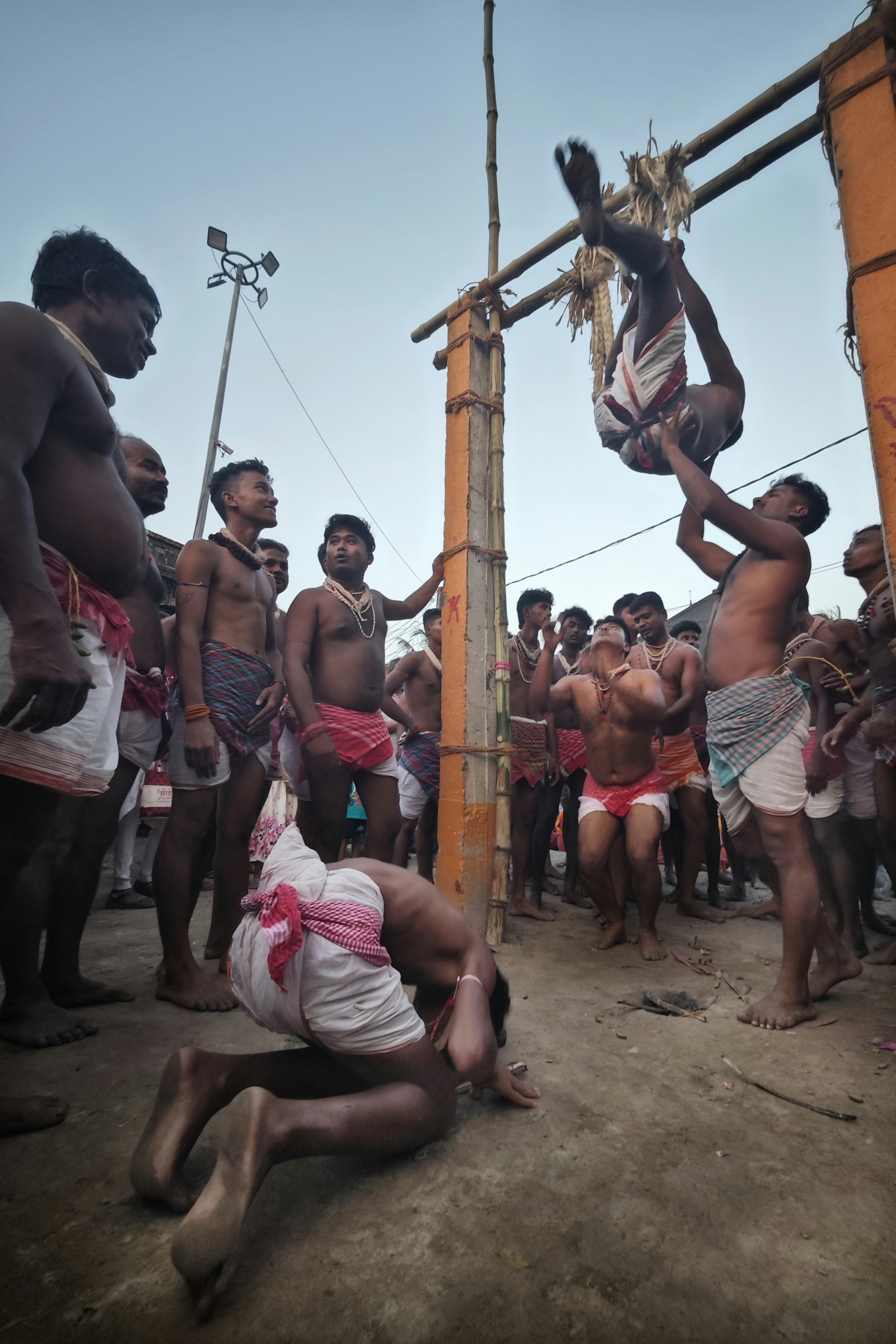 Los hombres realizan un ritual acrobático tradicional al aire libre.