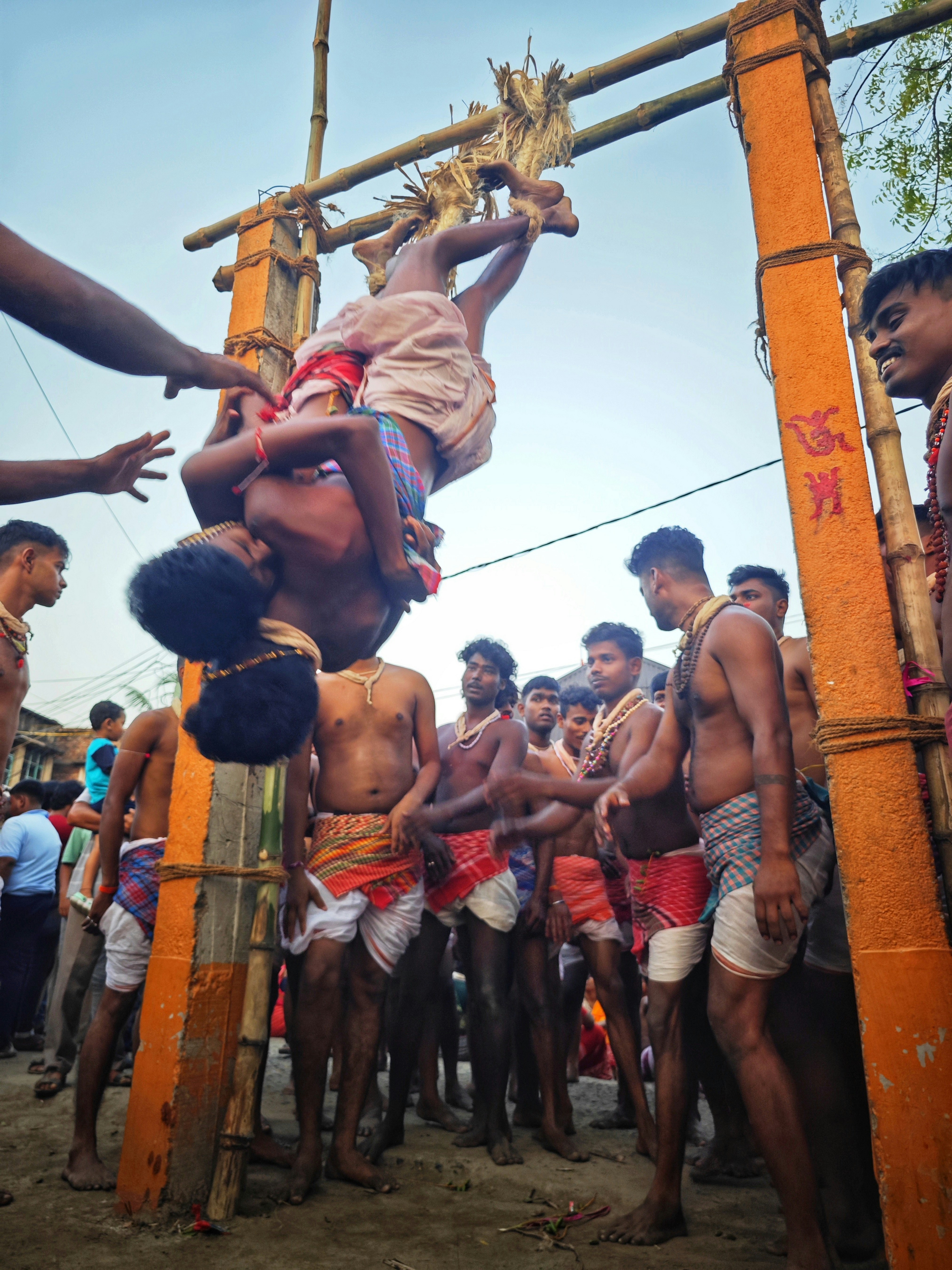Hombres realizando un ritual tradicional con un hombre boca abajo