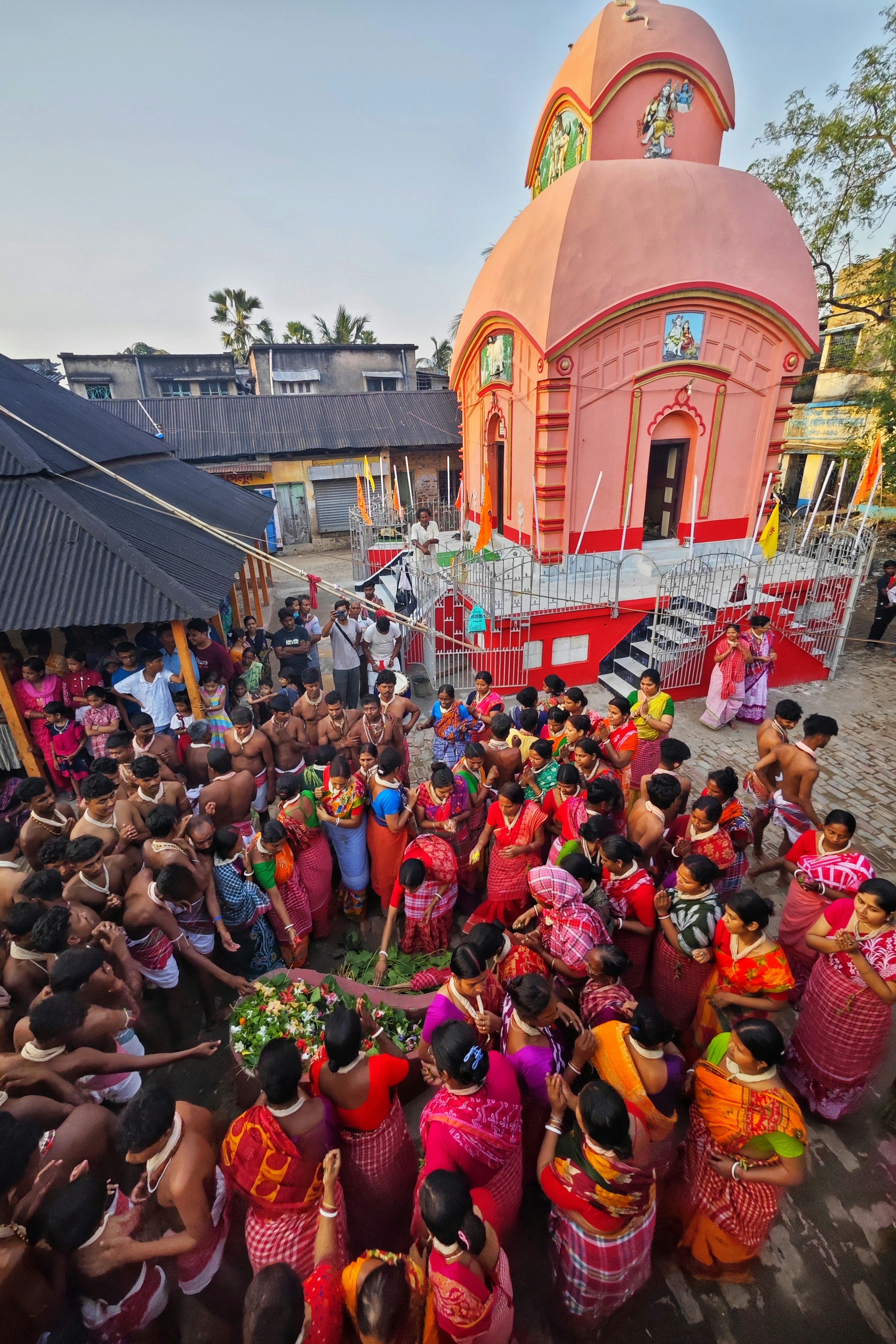 Una multitud se reúne alrededor de un templo rosa durante un festival.