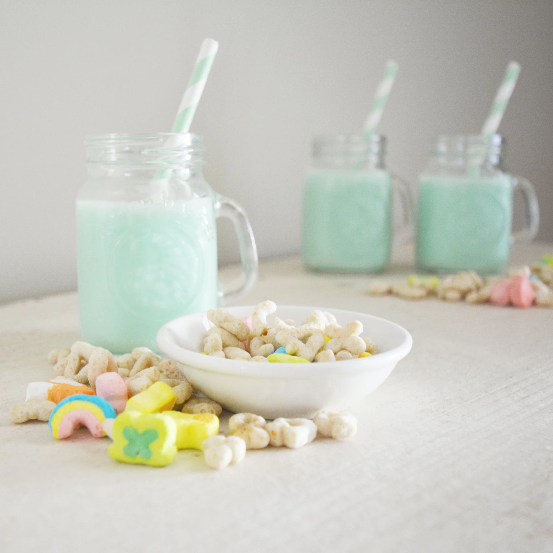 Three glasses of blue milk with cereal and marshmallows