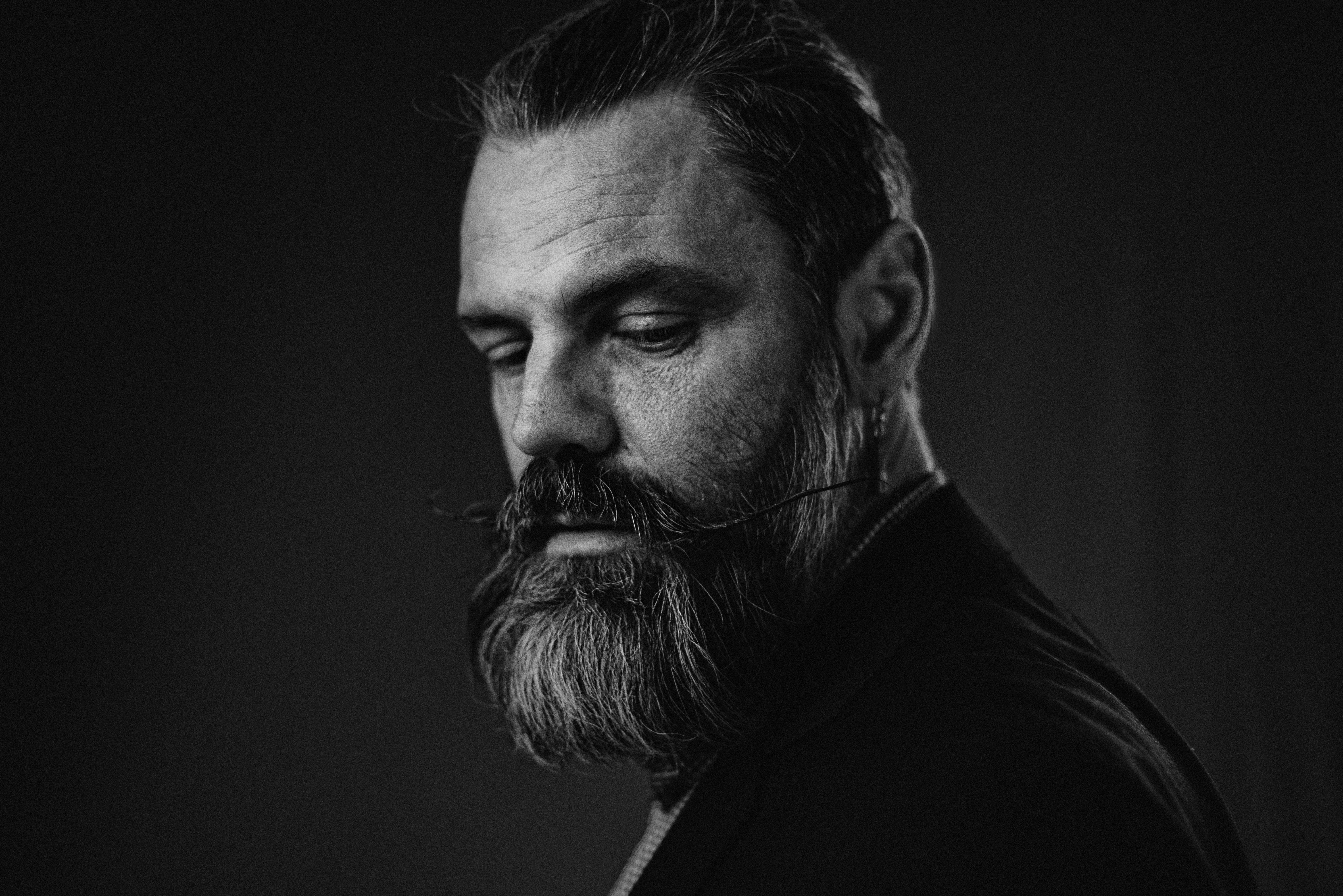 Un uomo premuroso con barba e baffi.