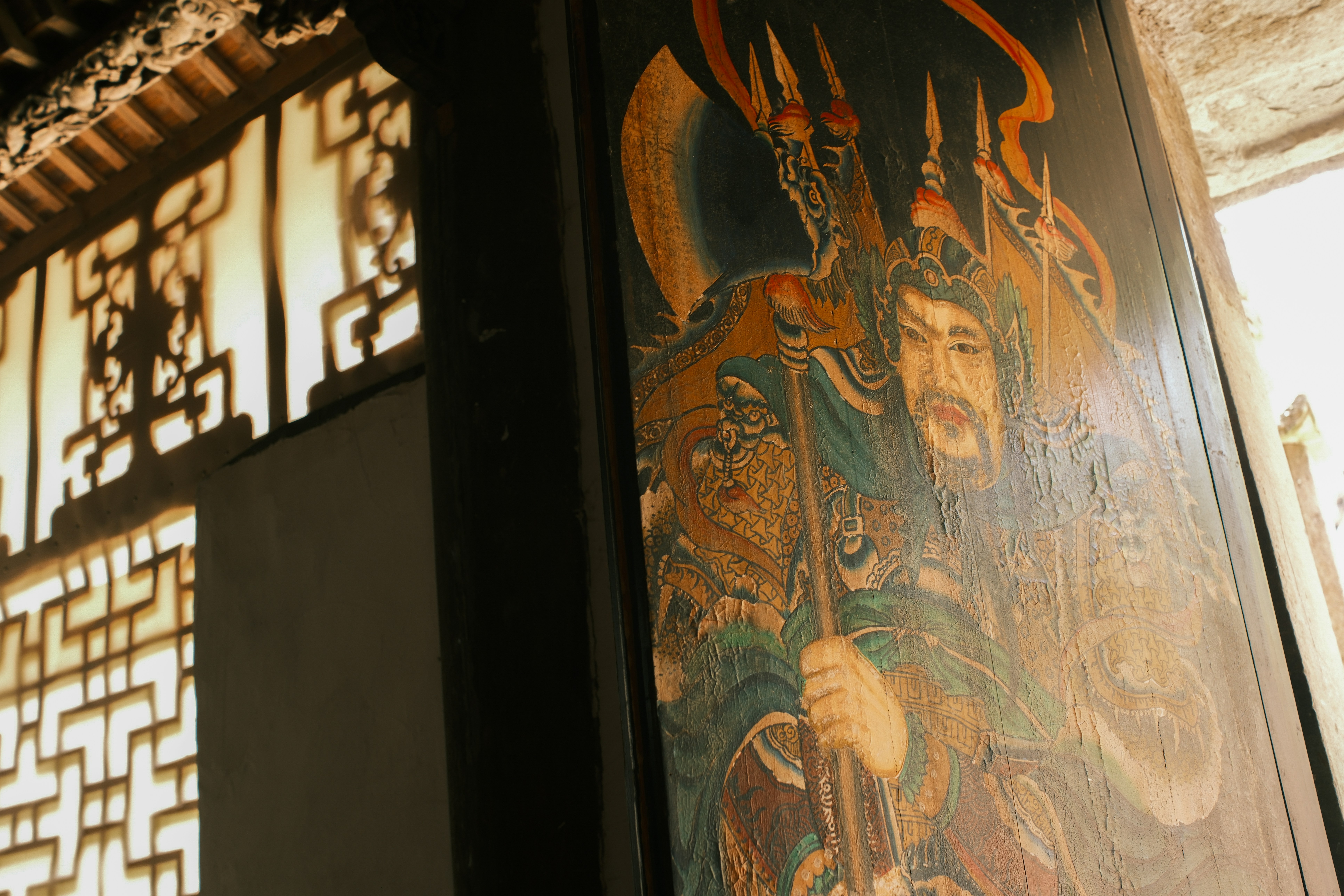 Painted warrior with dragon motif on wooden pillar