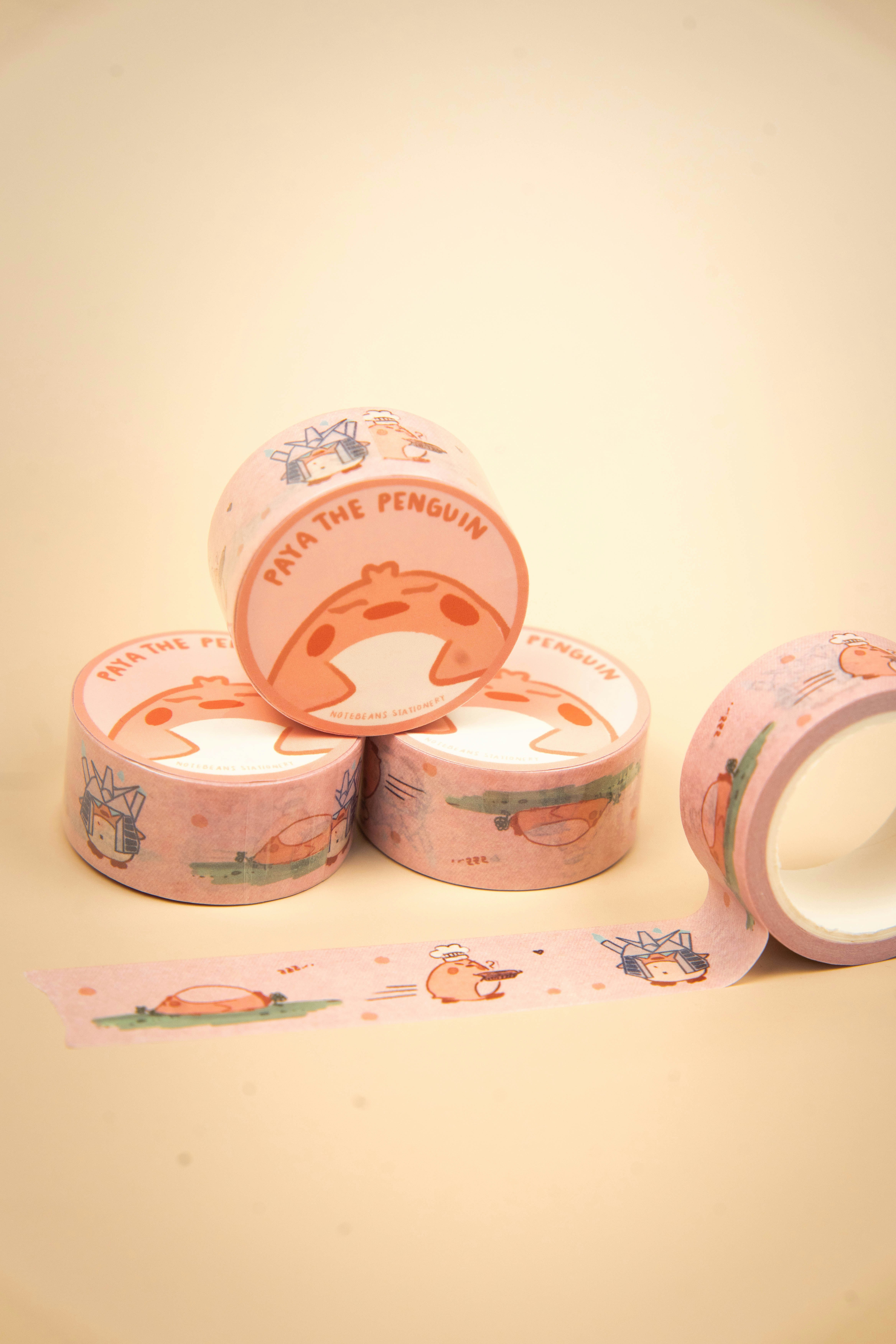 Rolls of pink washi tape with penguin designs.