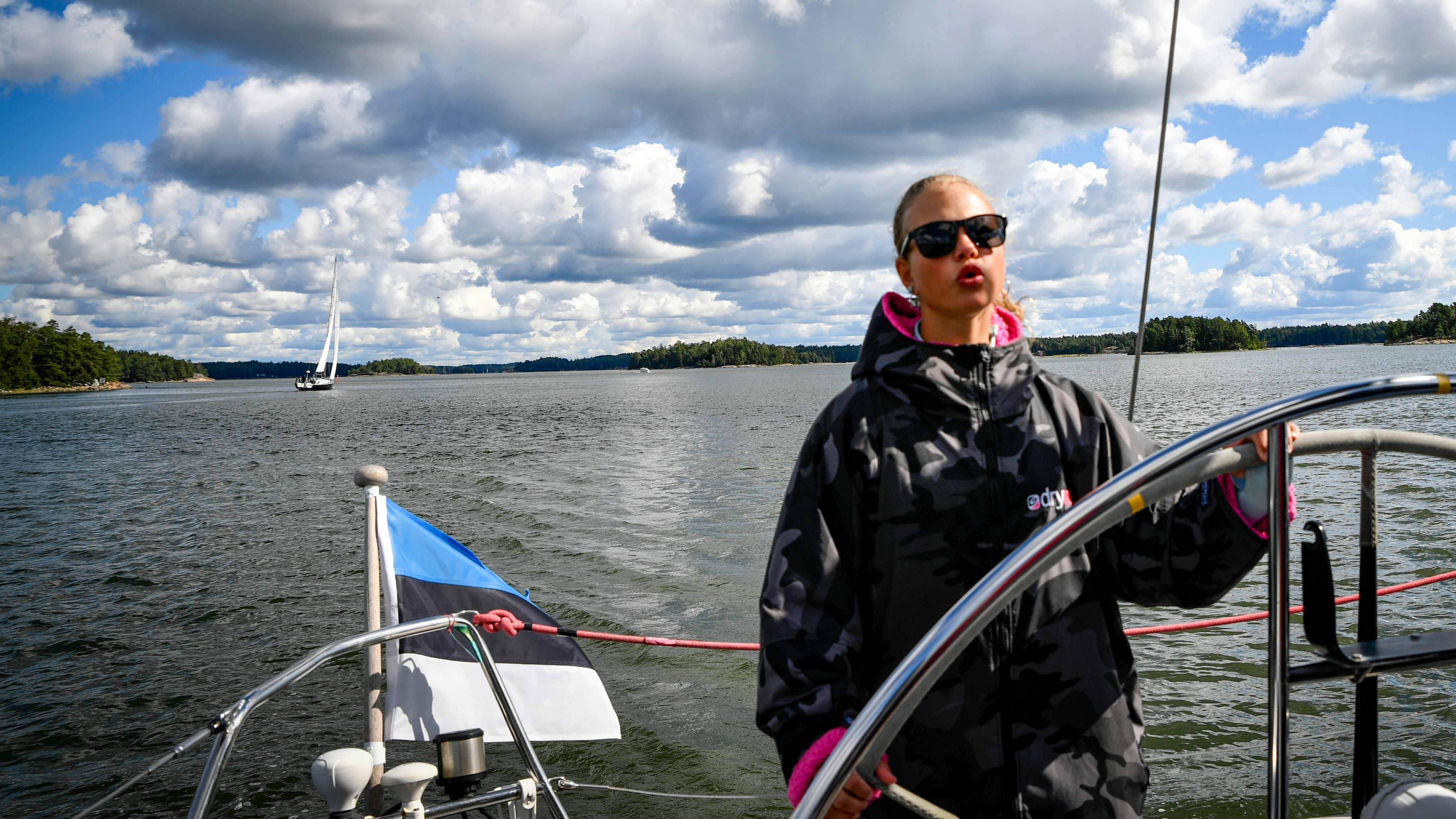 Woman steering a sailboat on a sunny day