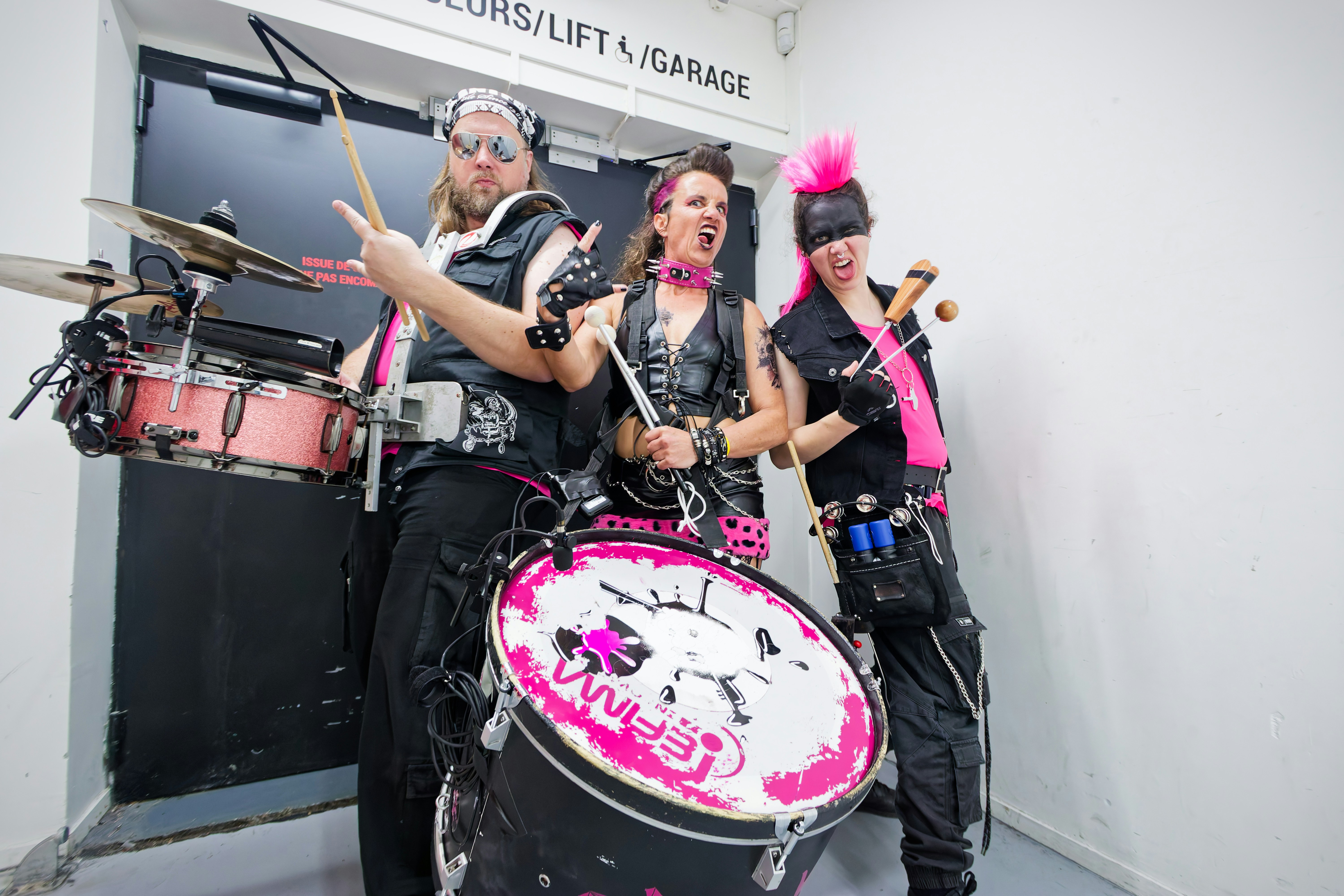Three musicians with pink accents playing instruments