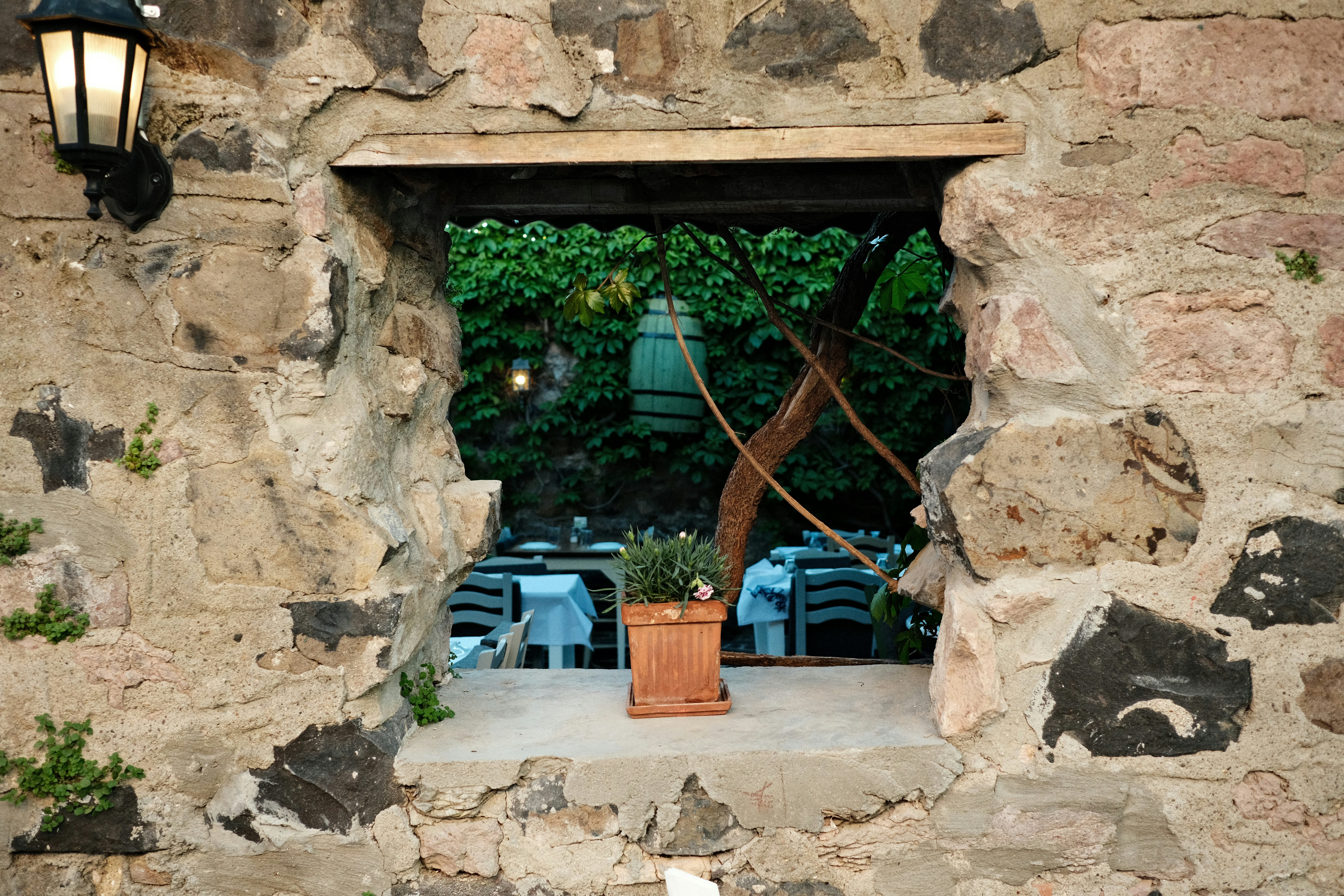 View of a restaurant patio through a stone window