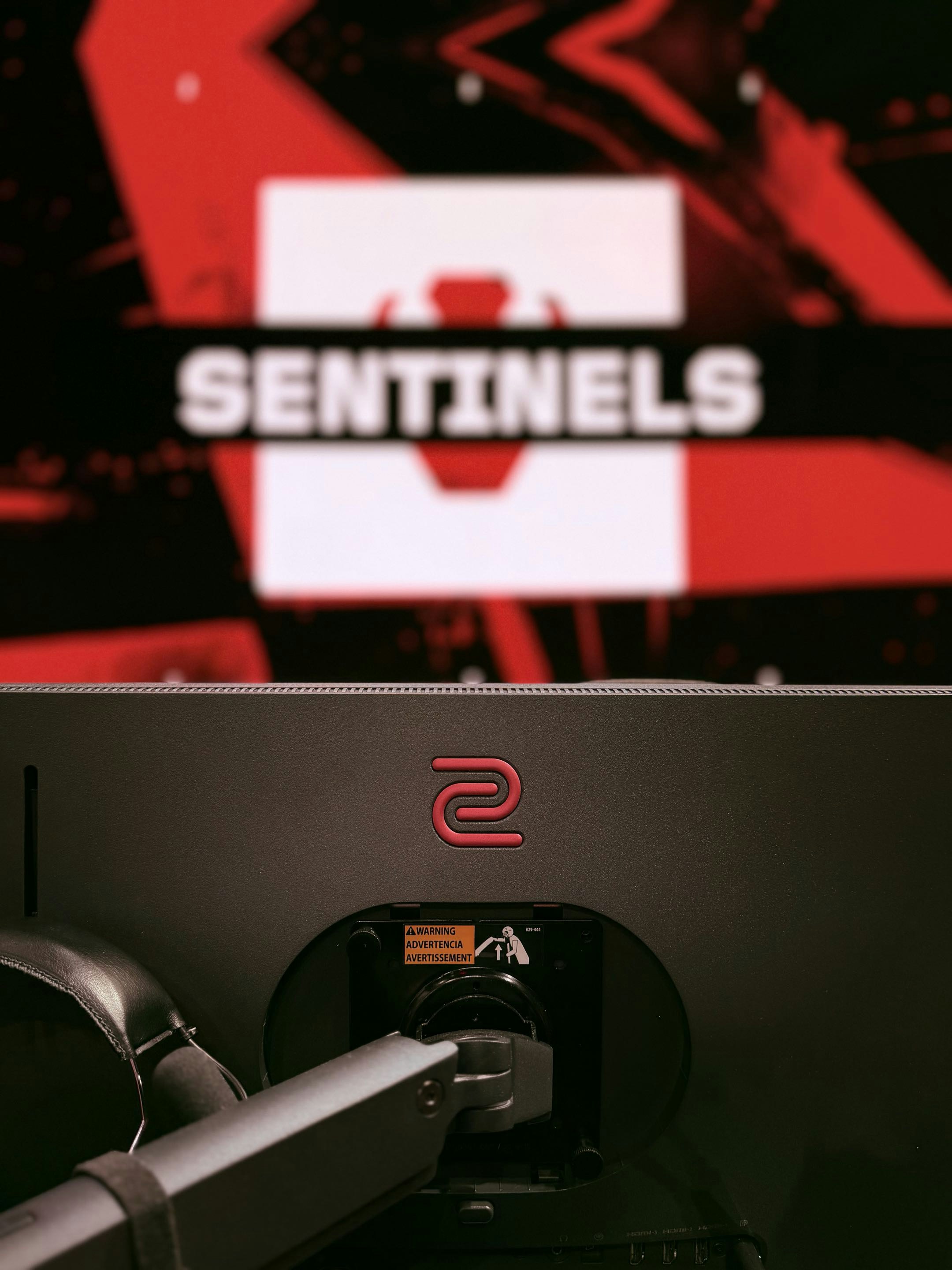 Monitor da gaming nero montato su un braccio articolato a una postazione.