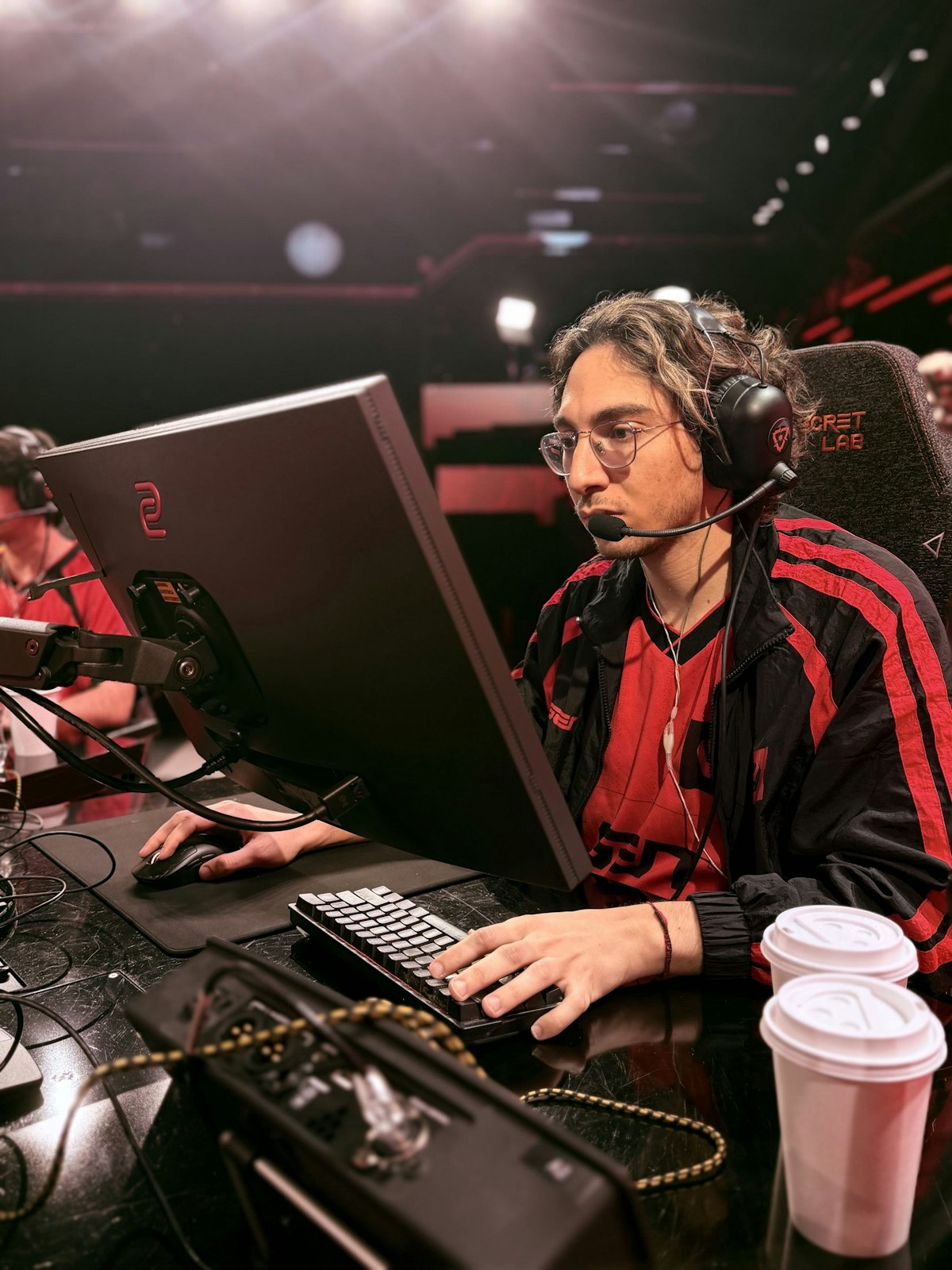 Jogador de Valorant no palco do VCT Americas, focado no PC — a Riot Games Arena onde os playoffs abrem nesta quinta