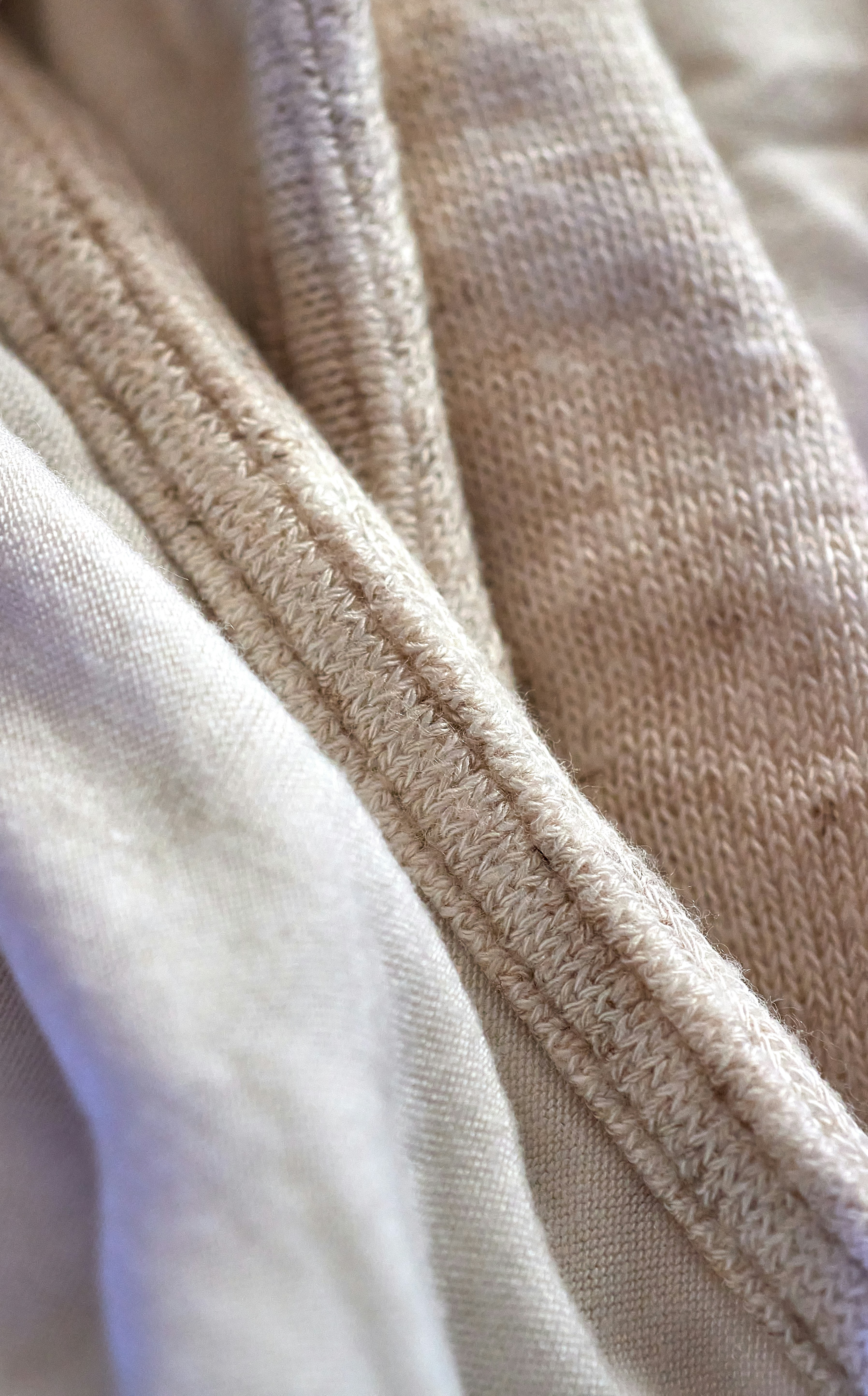Close-up of folded neutral-colored fabrics with different textures.