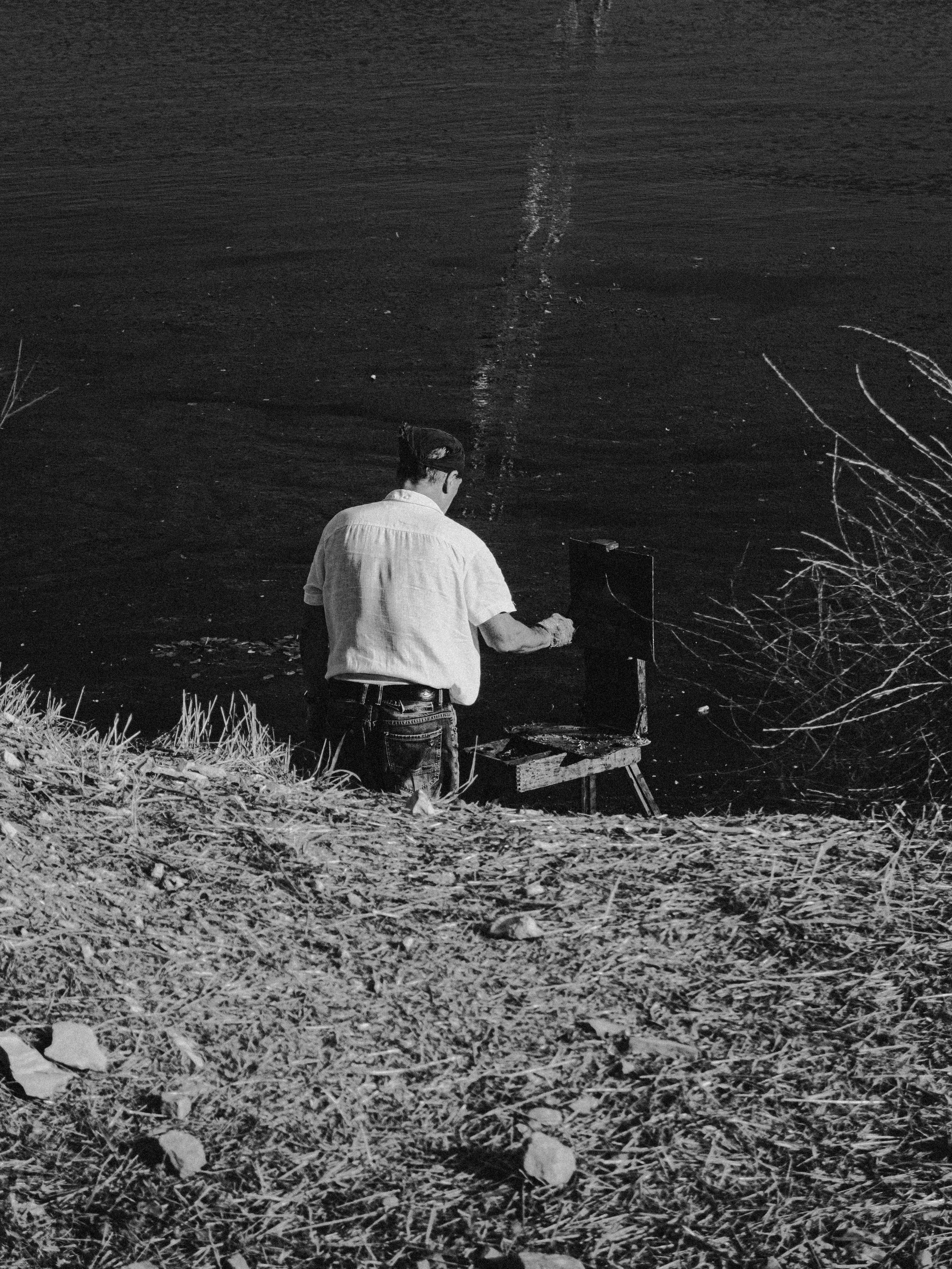 Un homme pêcheant au bord d’un lac calme par une journée ensoleillée
