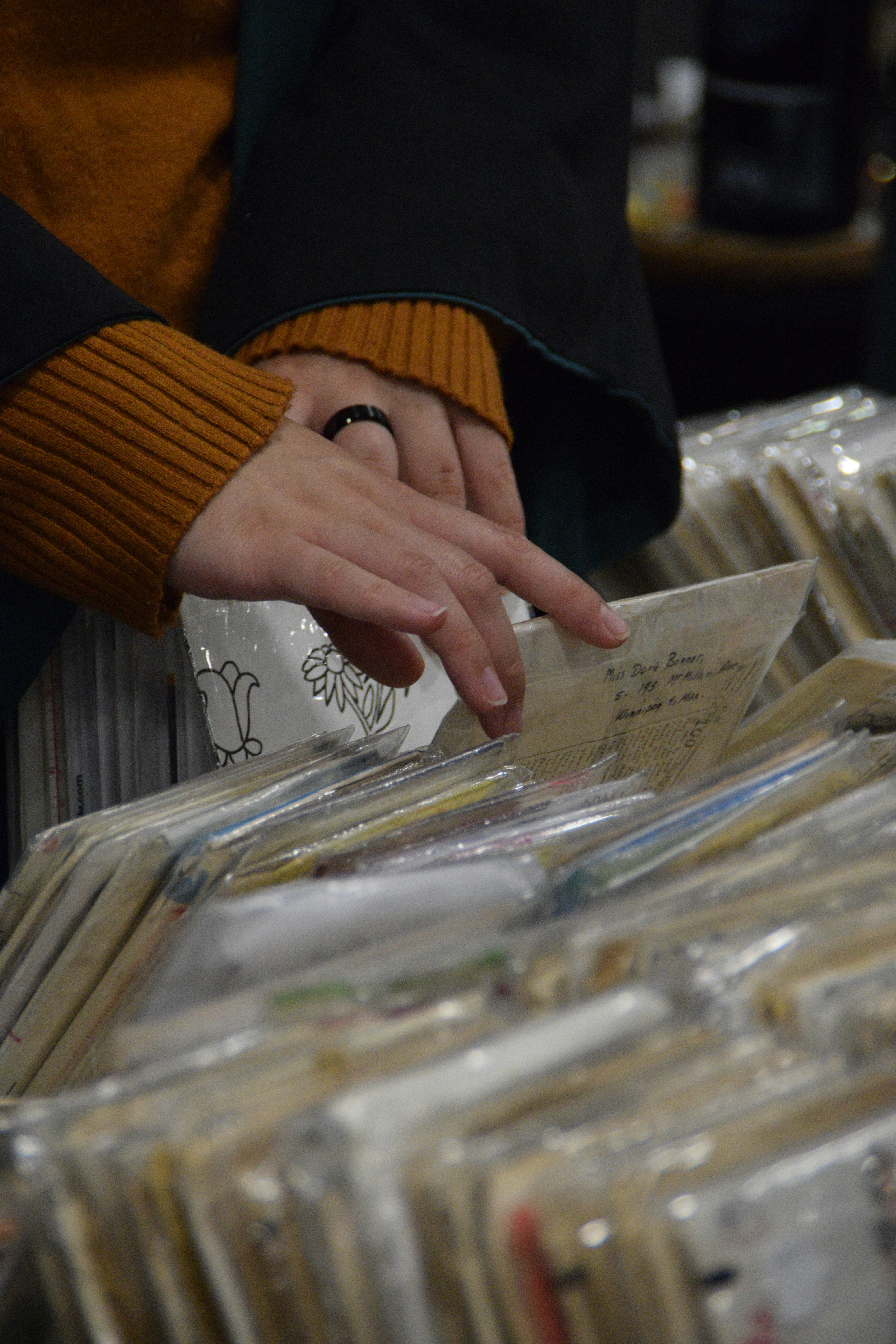 Hands sifting through records in a store