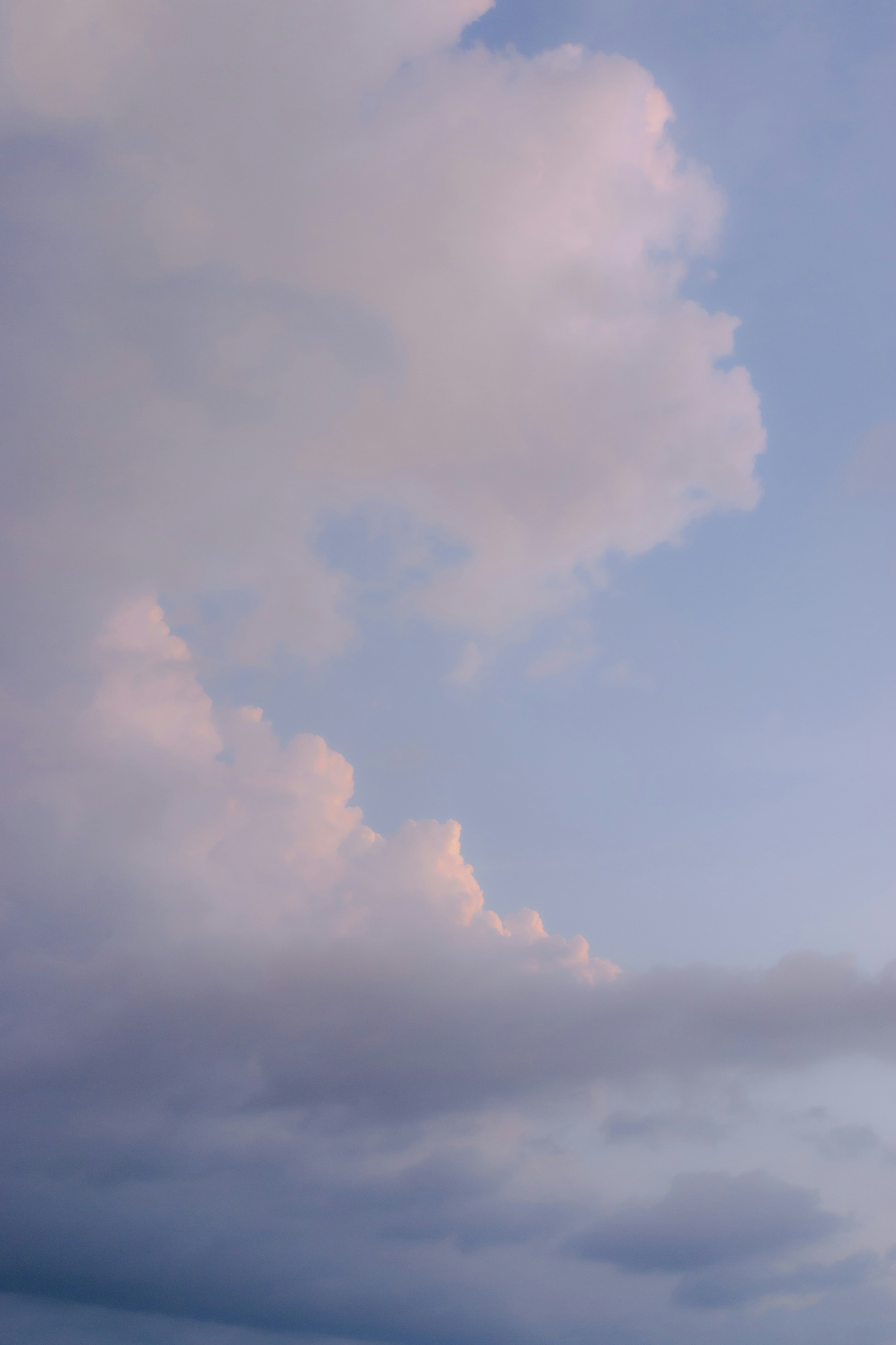 Soft pink and purple clouds in a pale blue sky.