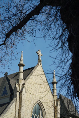 Stone church with cross against blue sky