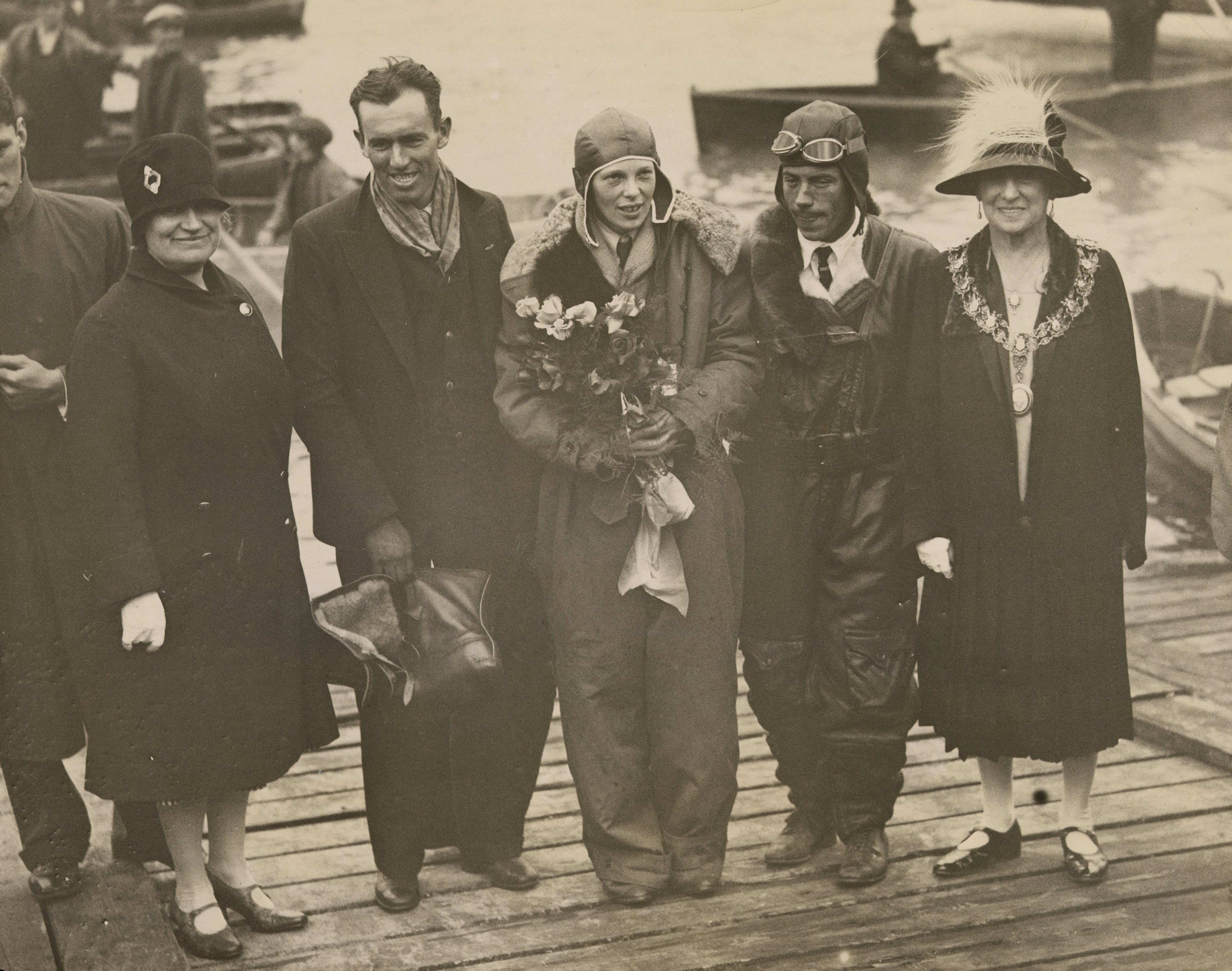 A group of people in vintage clothing on a dock