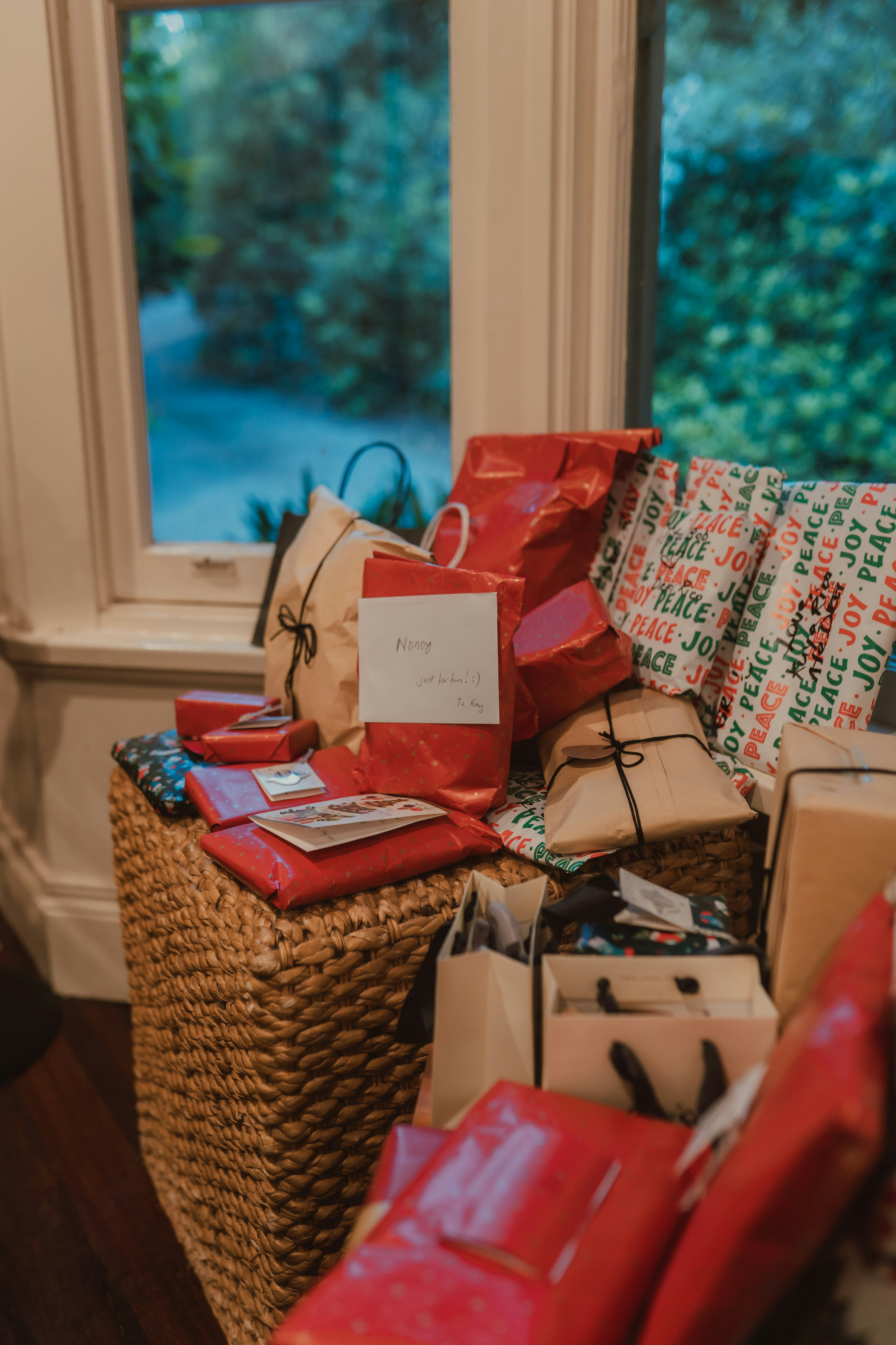 Pile of wrapped gifts near a window
