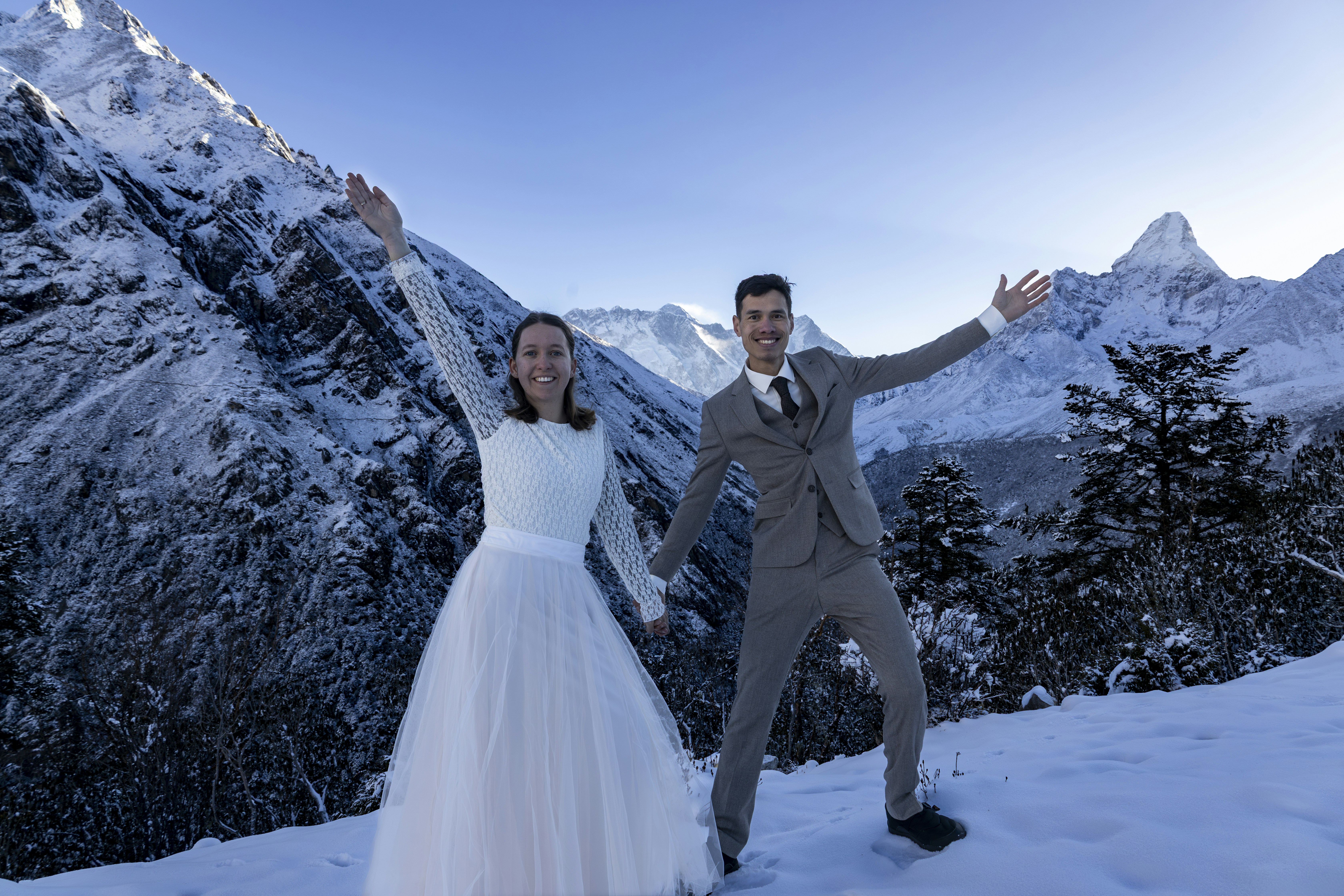 Novelli sposi che festeggiano in un paesaggio montuoso innevato