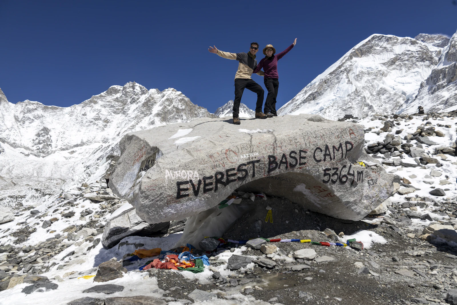 Travelers at Everest Base Camp with mountains behind them