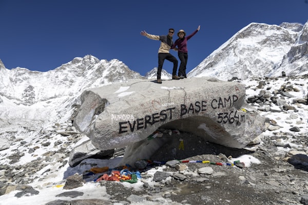 Trekkers celebrating at Everest Base Camp Nepal with Himalayan peaks in the background