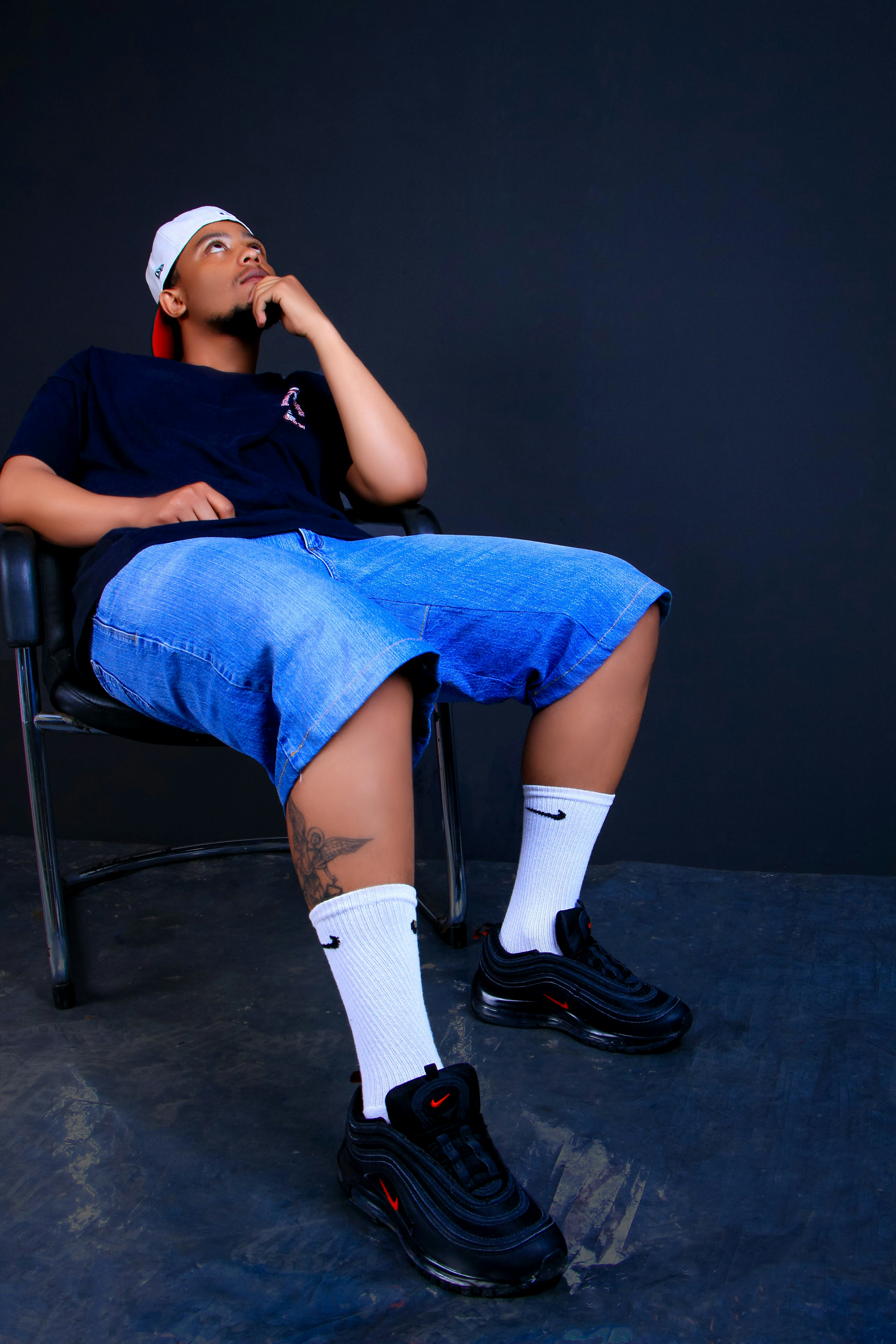 Homem de shorts e camiseta sentado na cadeira