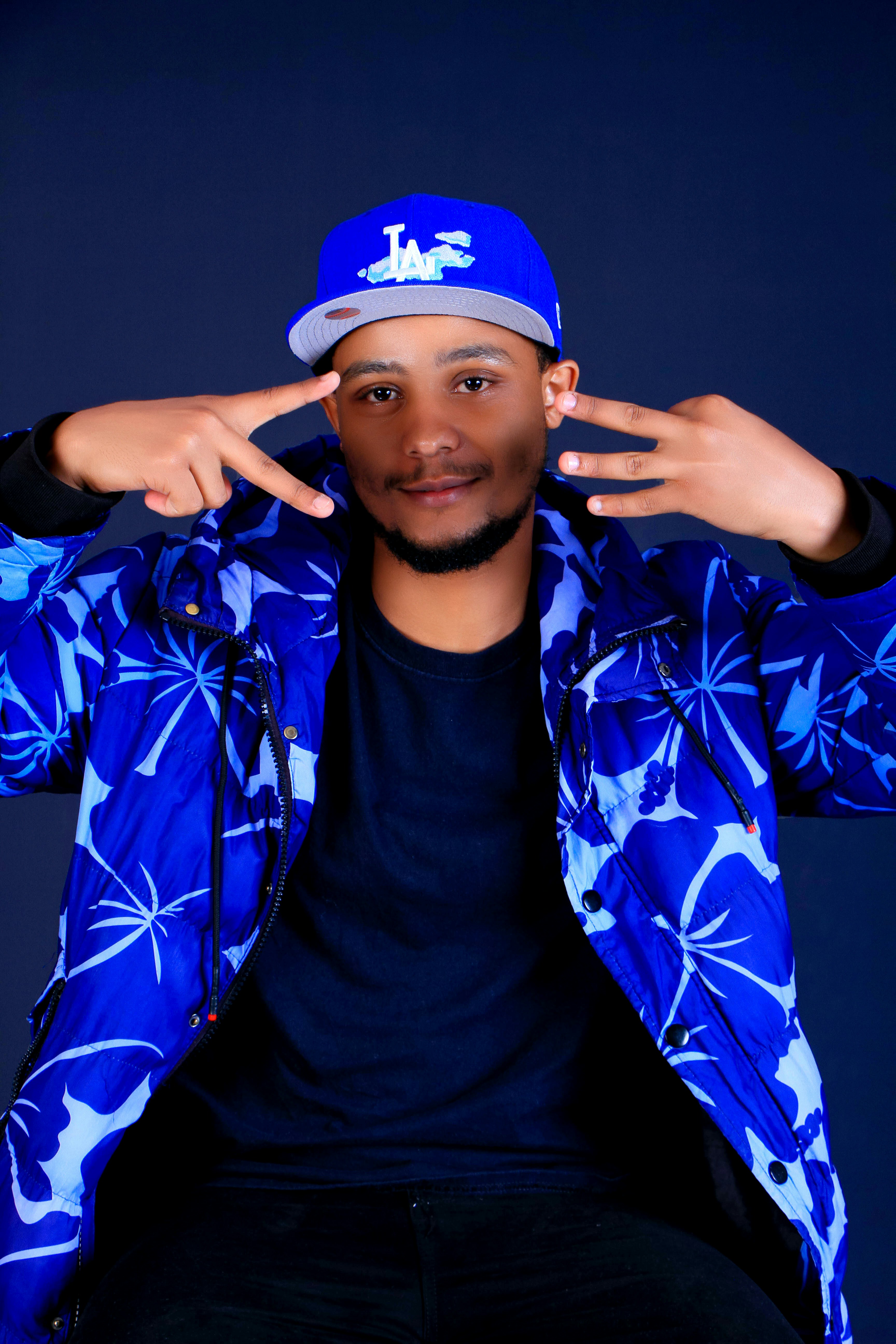 Homem com jaqueta azul floral e boné de beisebol