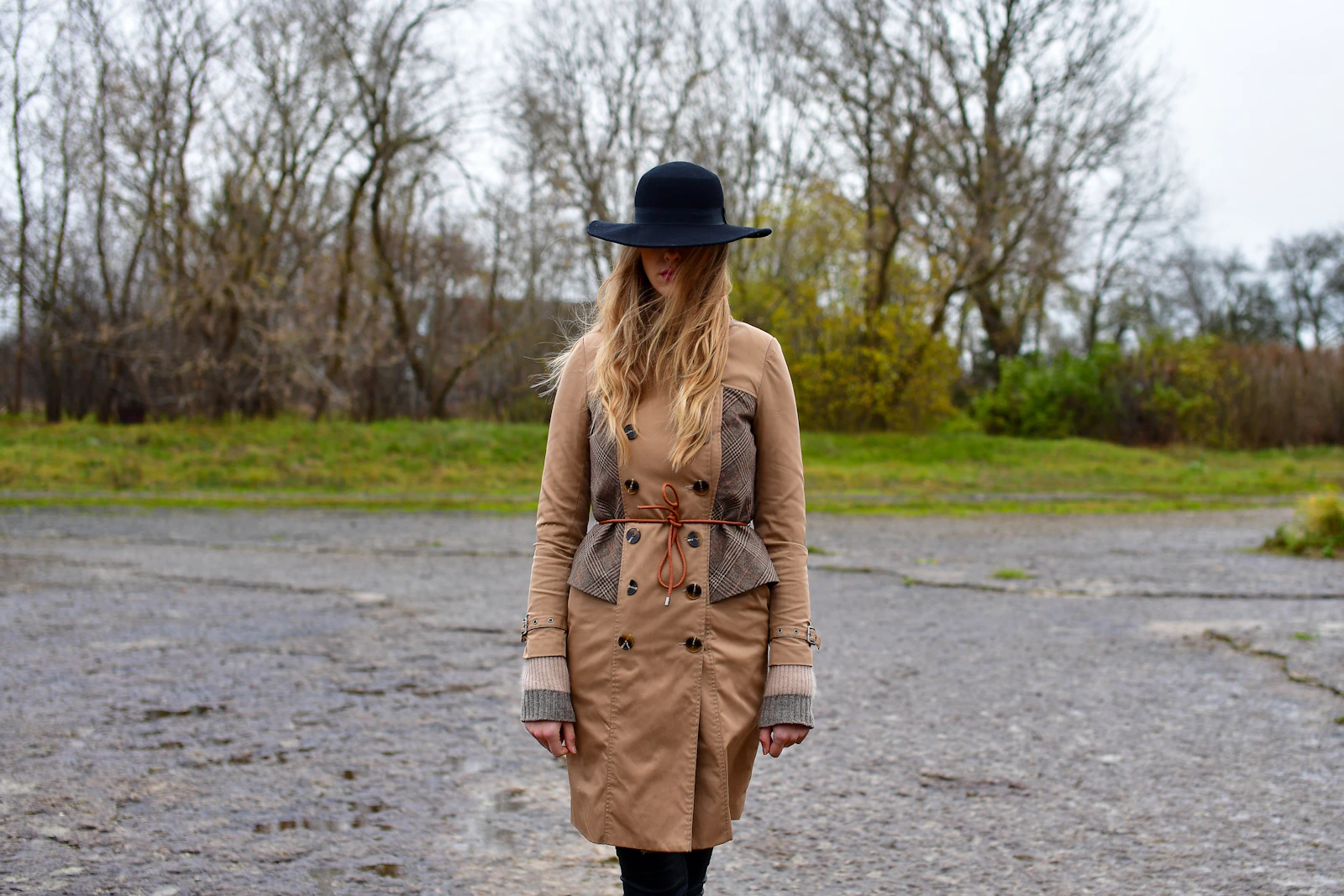 Woman in a hat walking through a countryside field in the evening