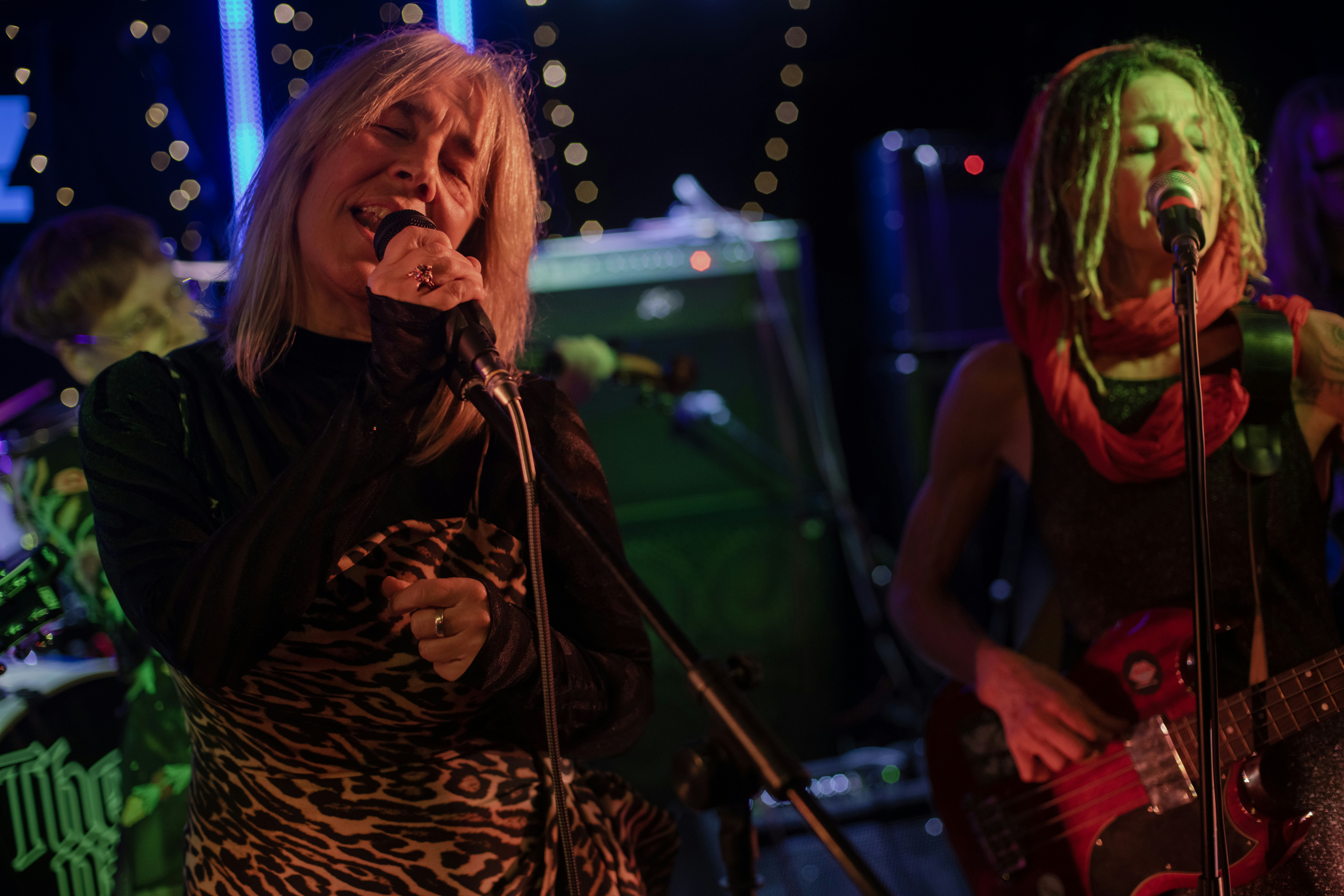 Zwei Frauen, die auf der Bühne singen und Instrumente spielen.