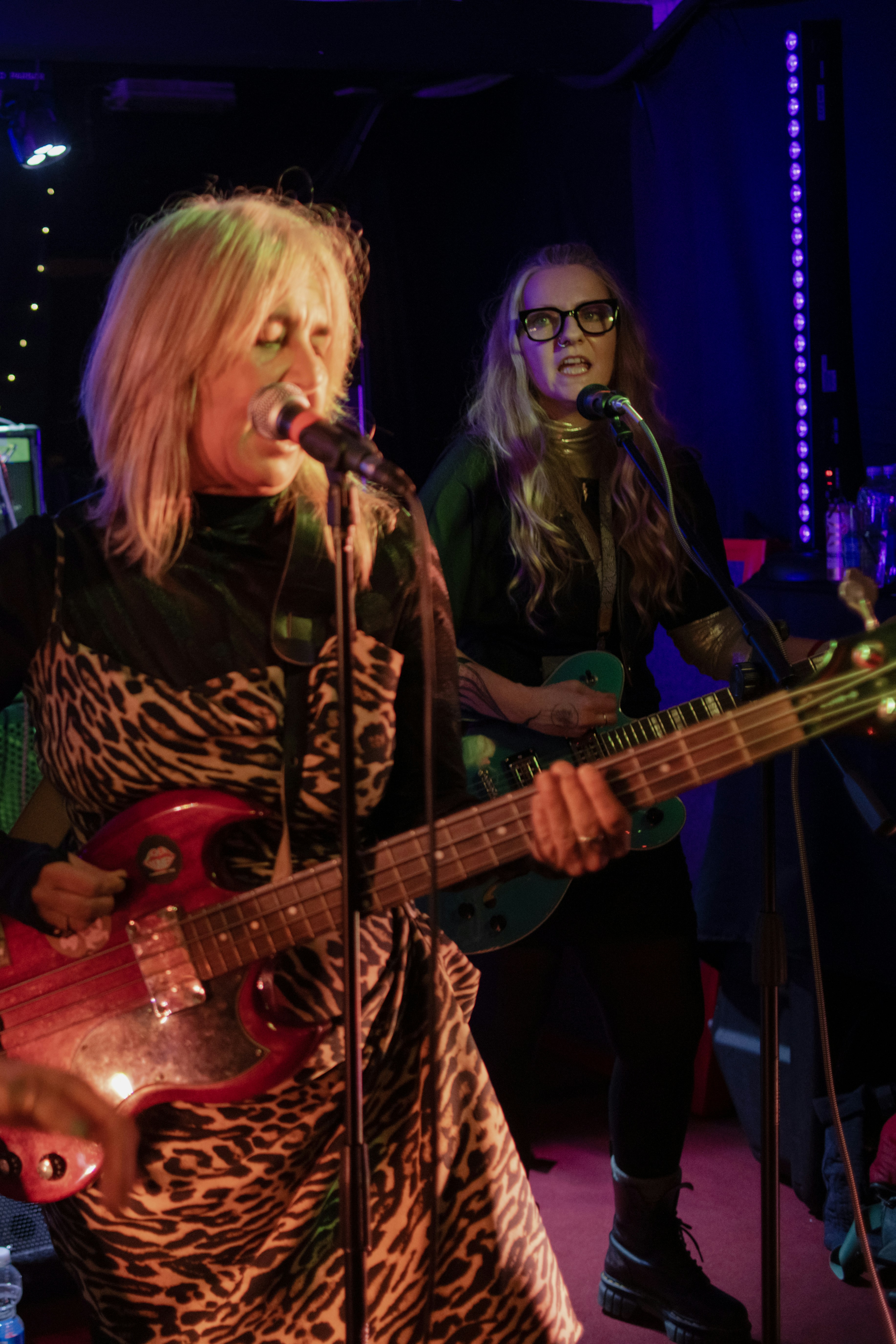 Two women playing guitars on stage