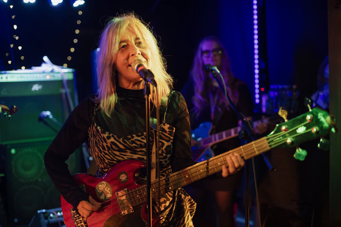 Female guitarist performing live with a band