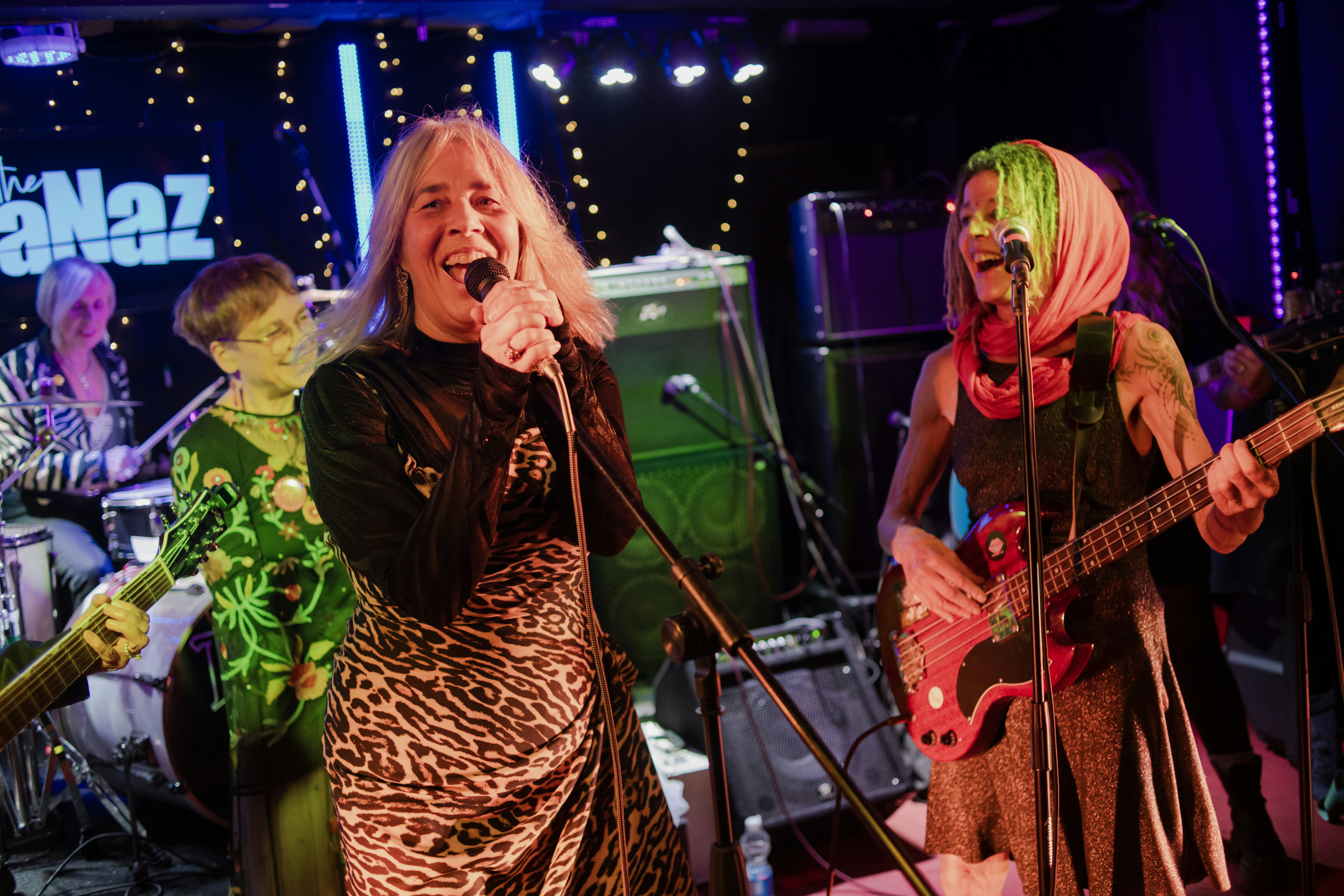A band performing live music on stage with colorful lighting.