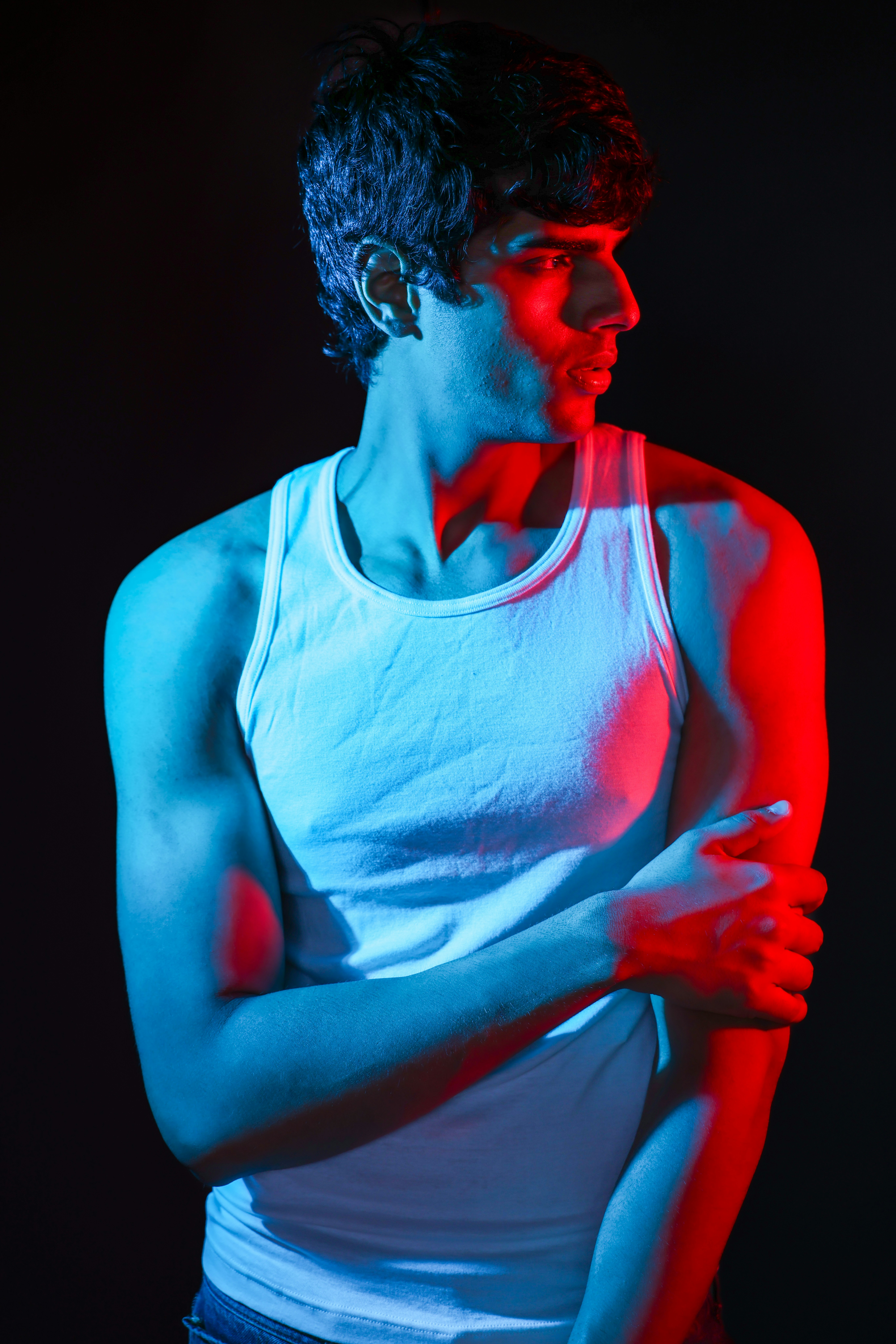 Homem de regata branca com iluminação vermelha e azul