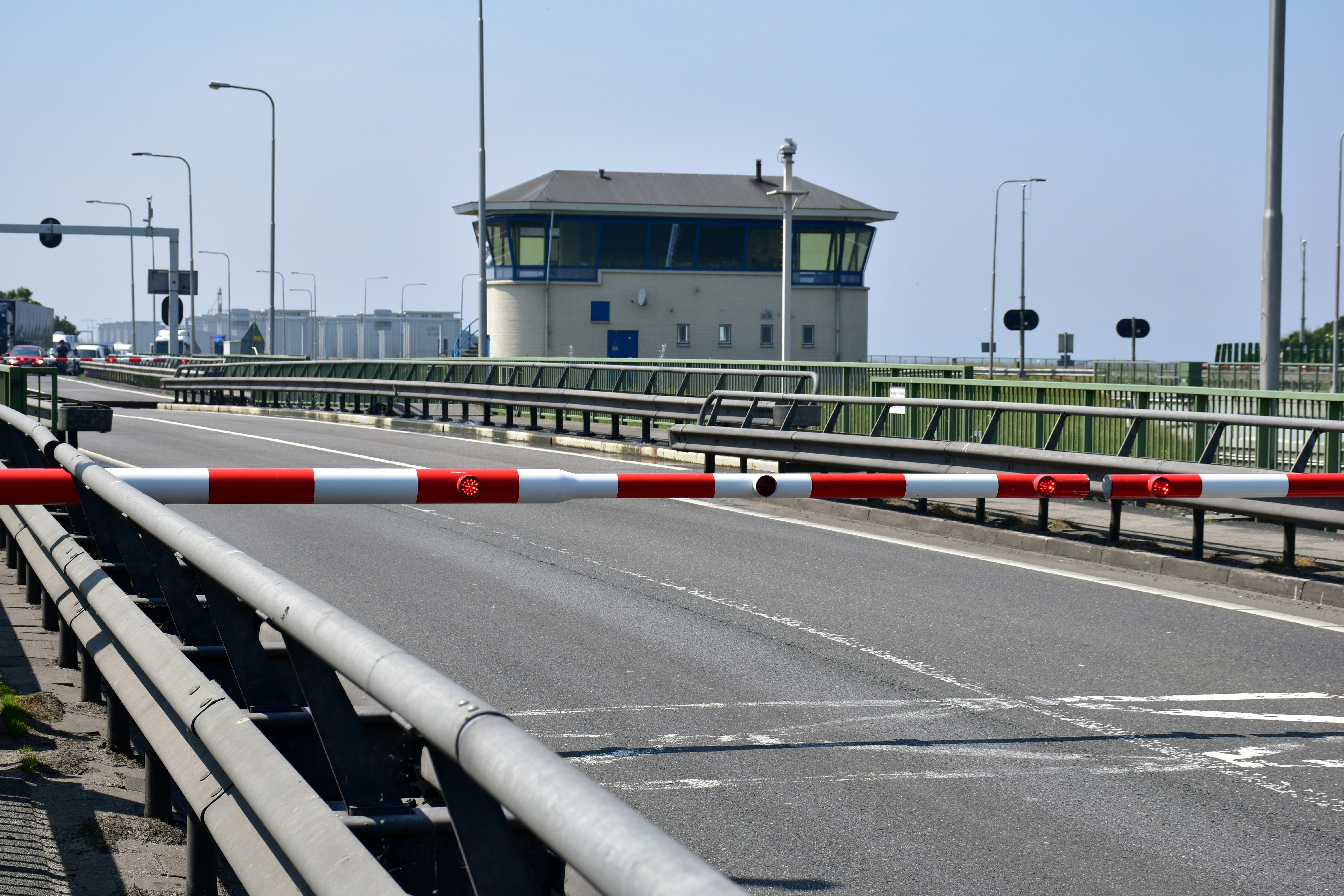 A road with a barrier and a control tower building.