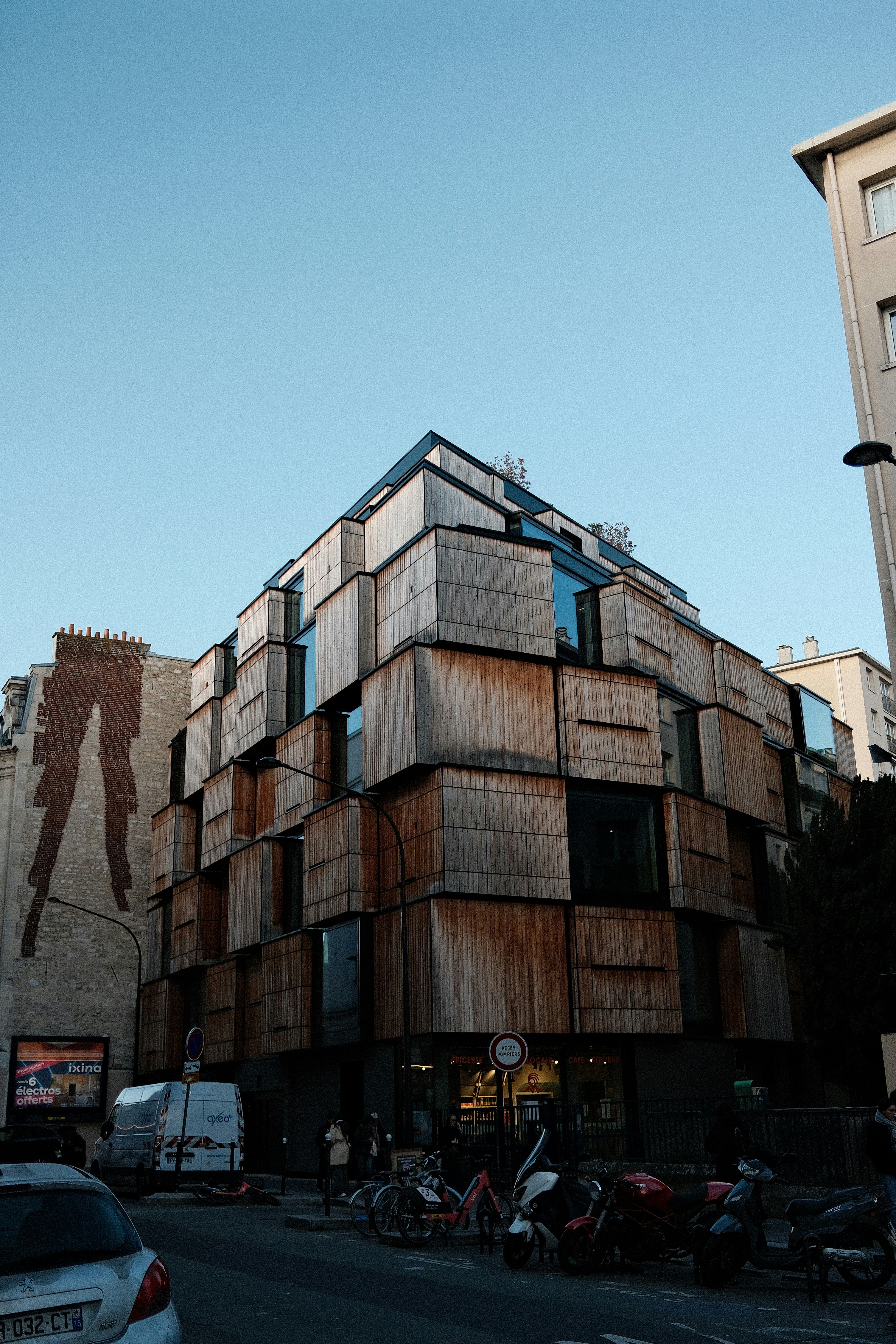 Bâtiment moderne avec façade en bois et design géométrique.