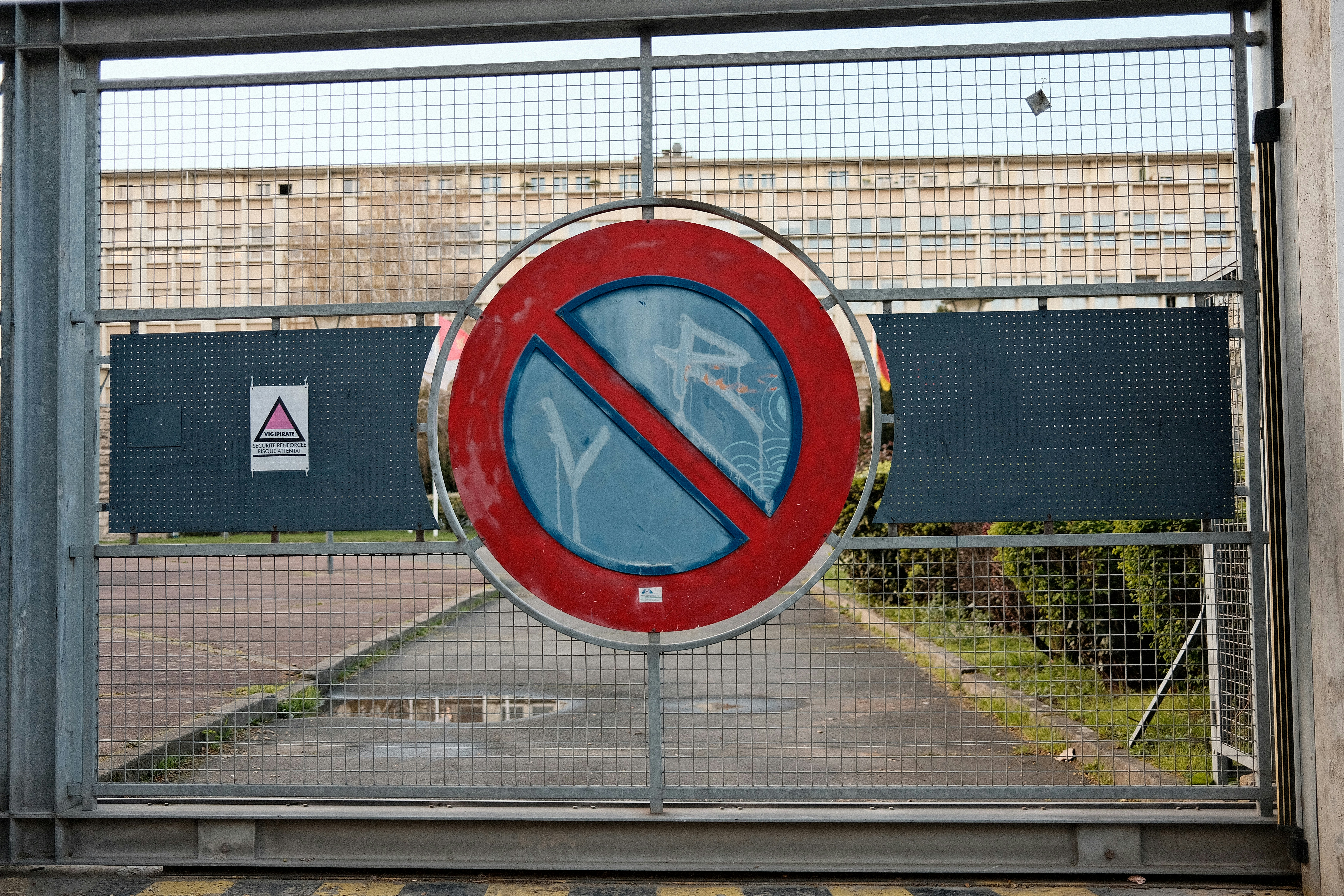 Un panneau rouge et bleu interdisant le stationnement sur une porte.