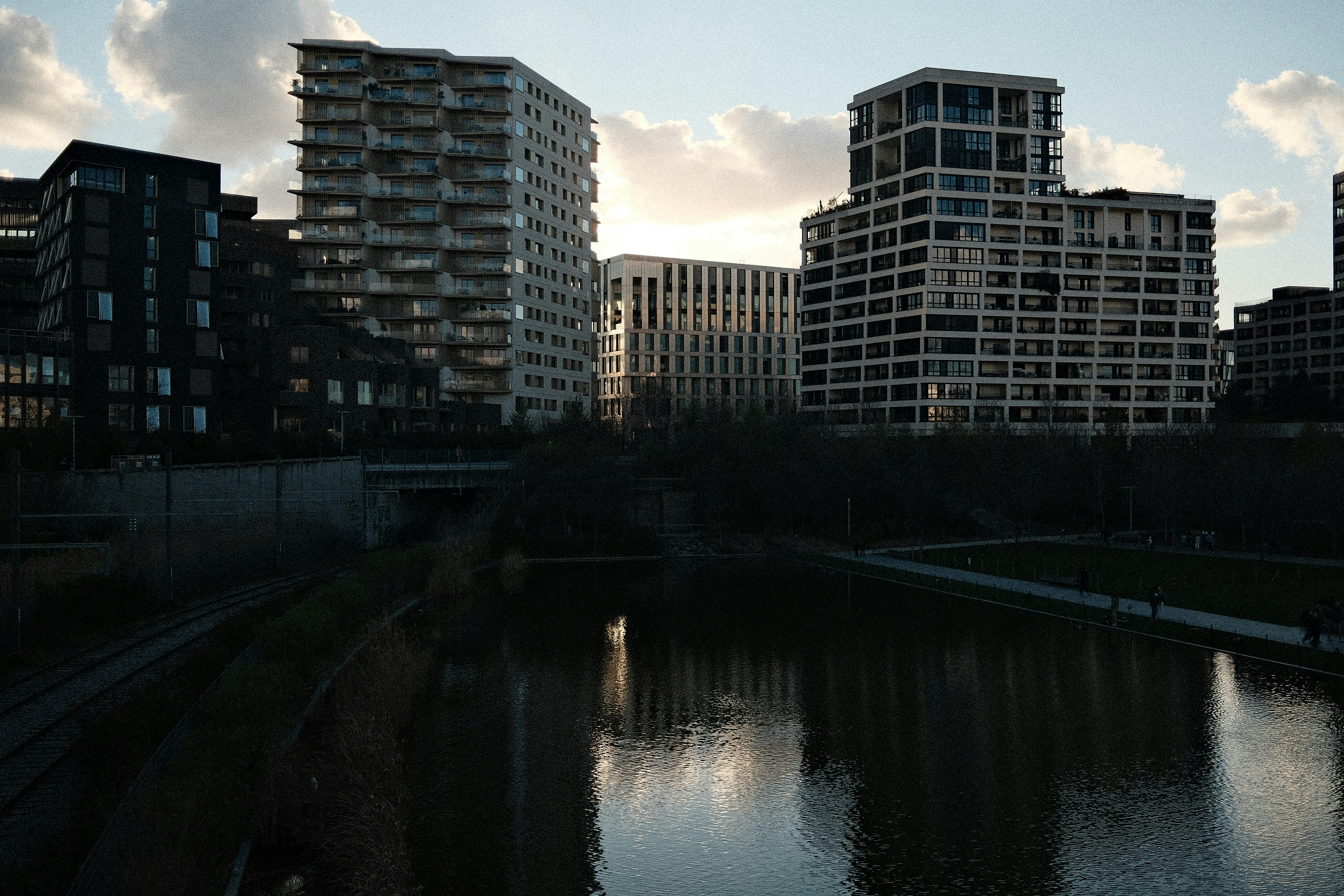 Des bâtiments modernes se reflétaient dans un canal calme au crépuscule