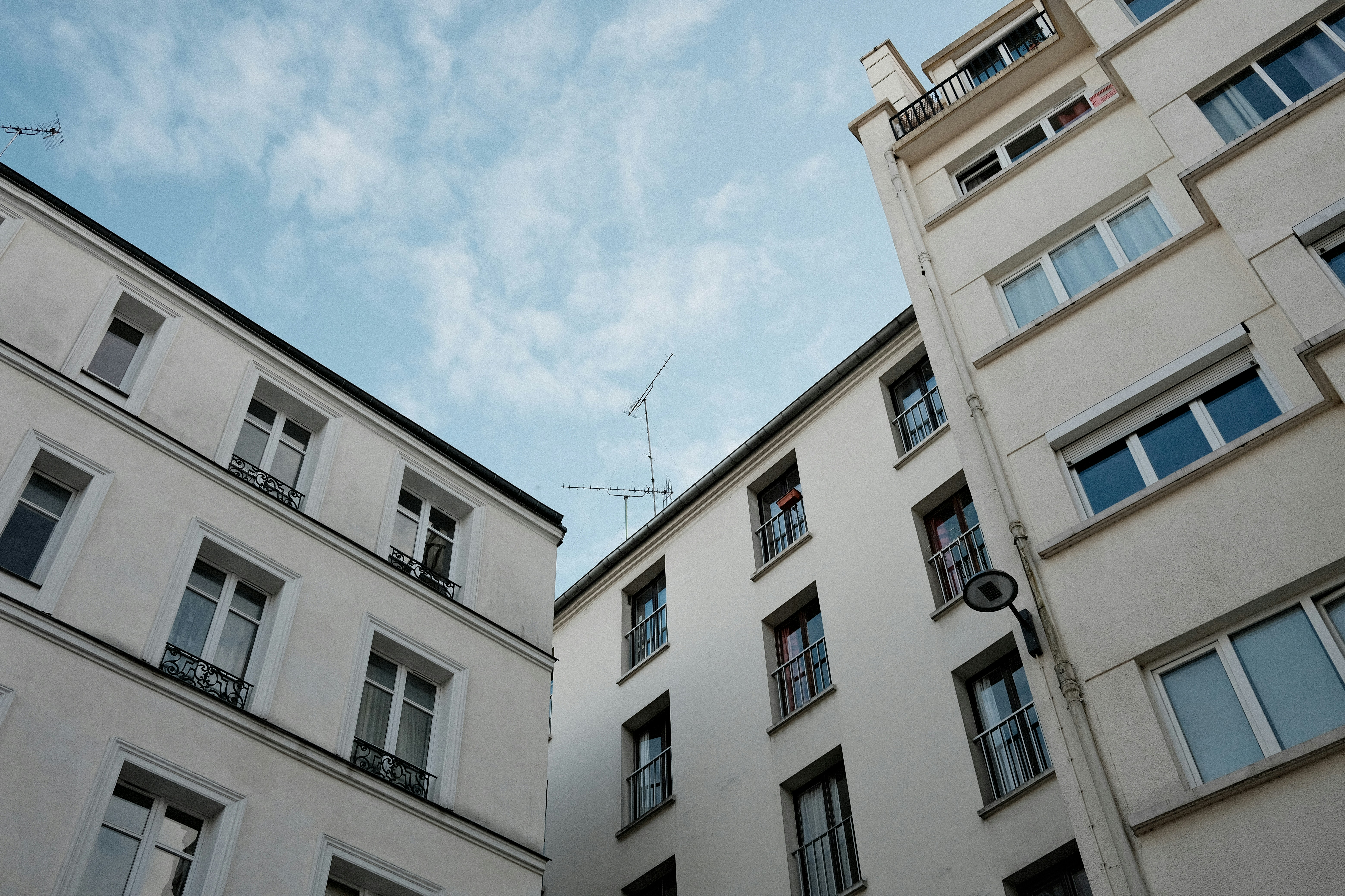 De hauts bâtiments blancs contre un ciel bleu nuageux