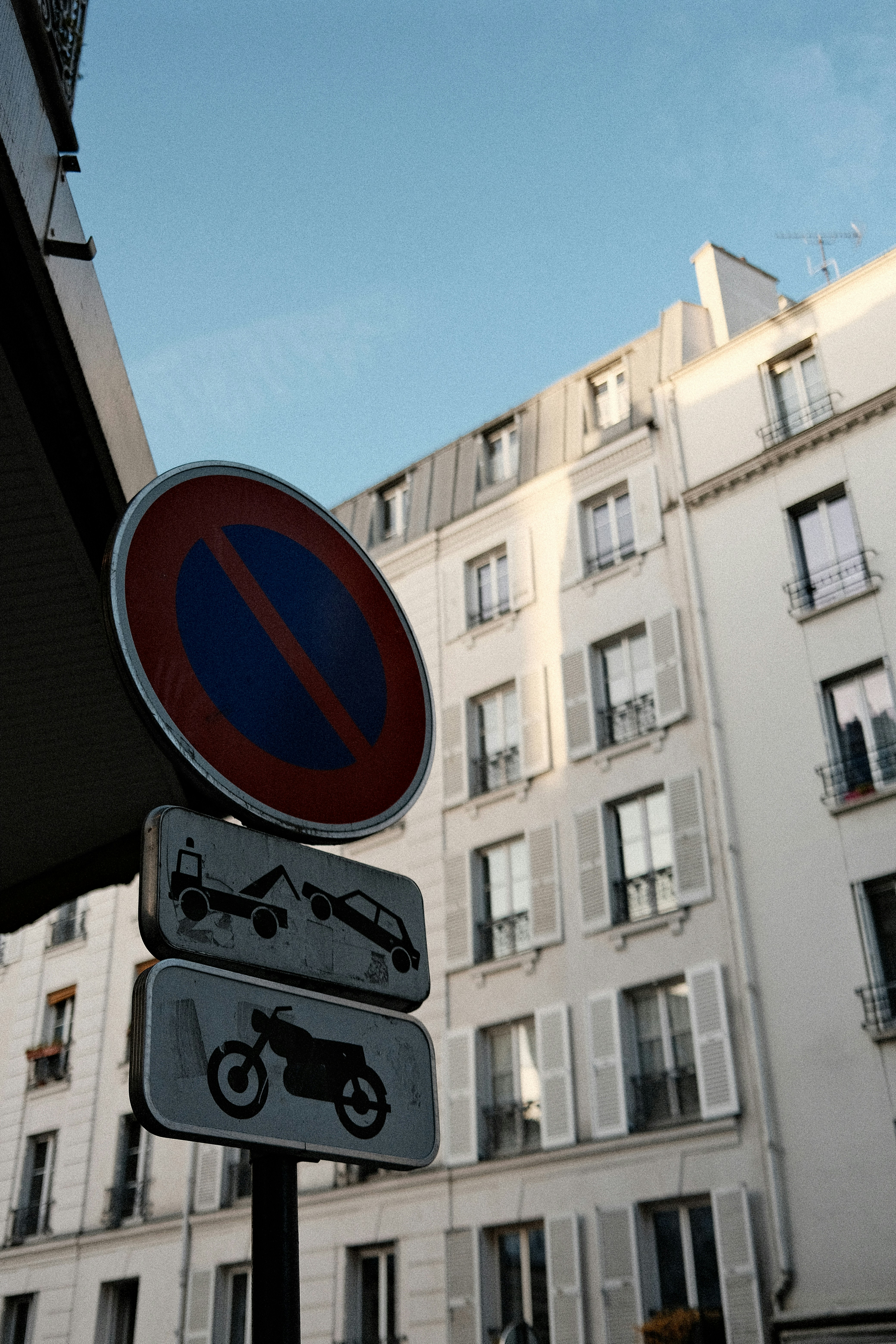 Panneaux de stationnement interdits avec des immeubles d’appartements en fond