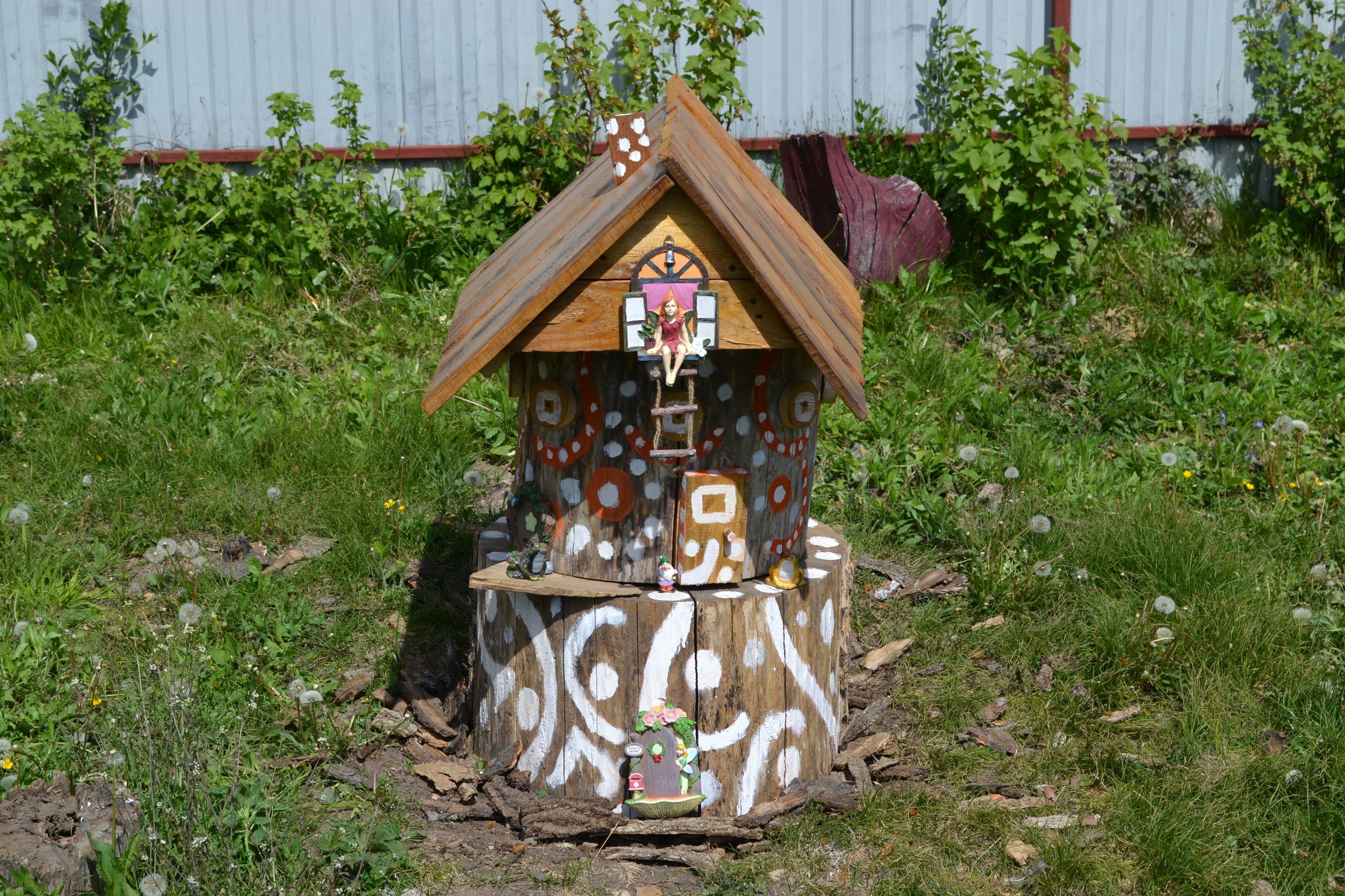 Ein dekoratives hölzernes Vogelhaus mit bunten Mustern.