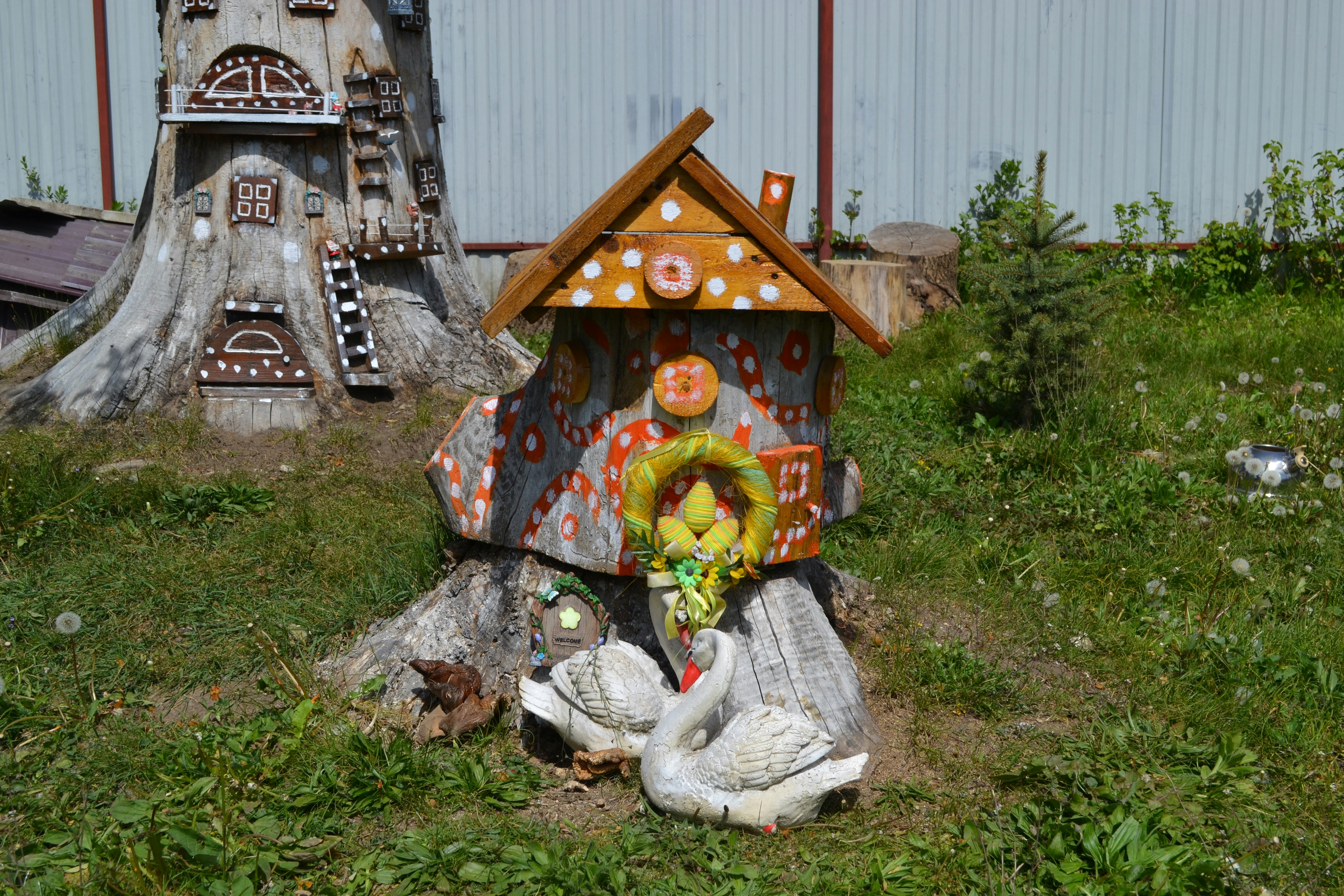 Dekorative Holzskulpturen eines Hauses und Schwäne