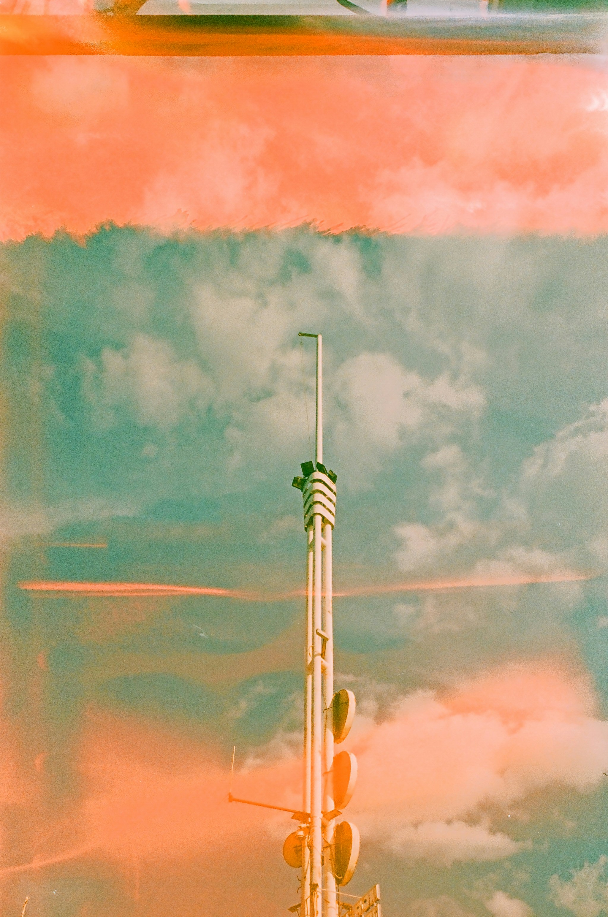 Tall communication tower against a cloudy sky