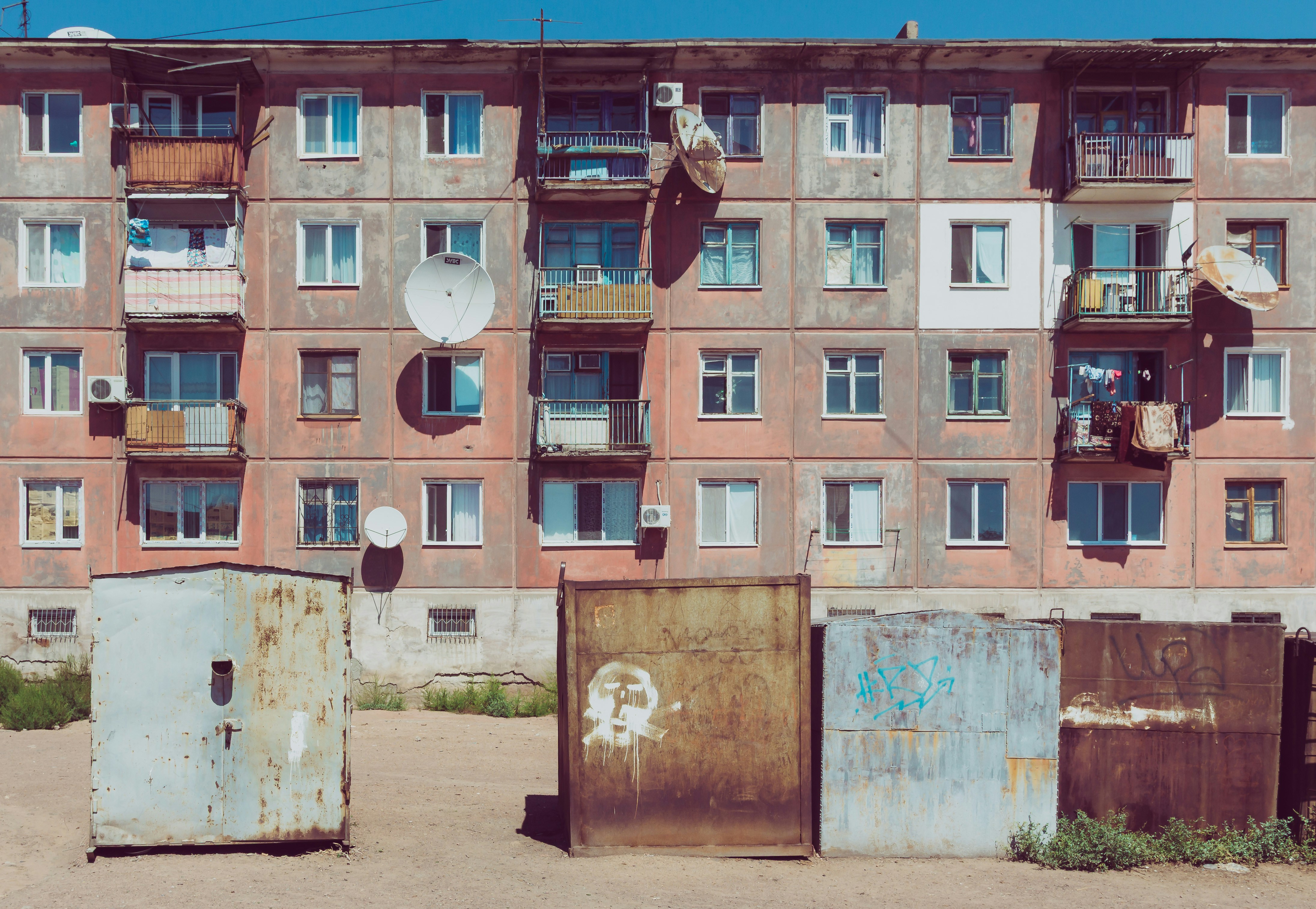 Old apartment building with rusty garages in front