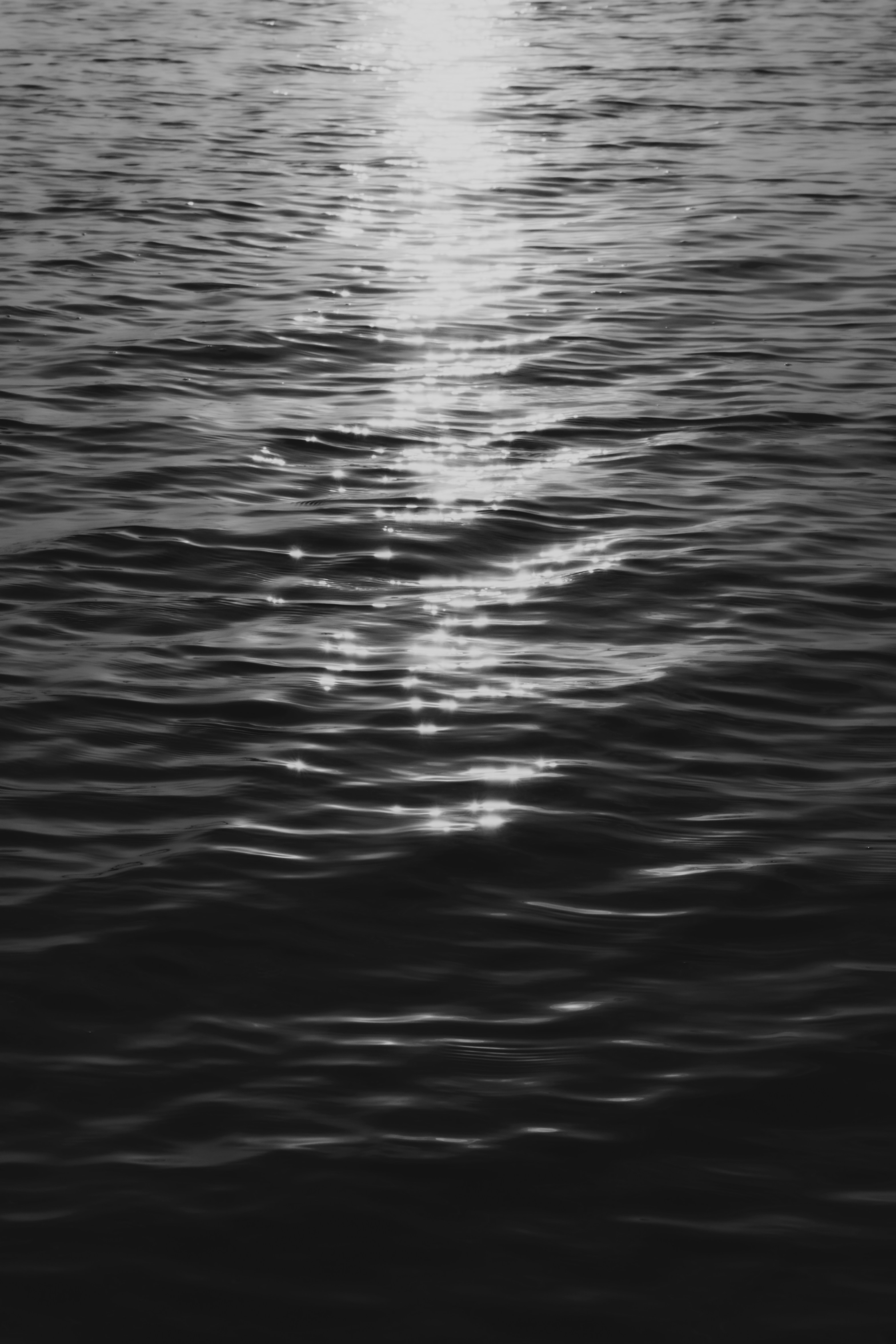 Sunlight reflecting on rippling dark water surface