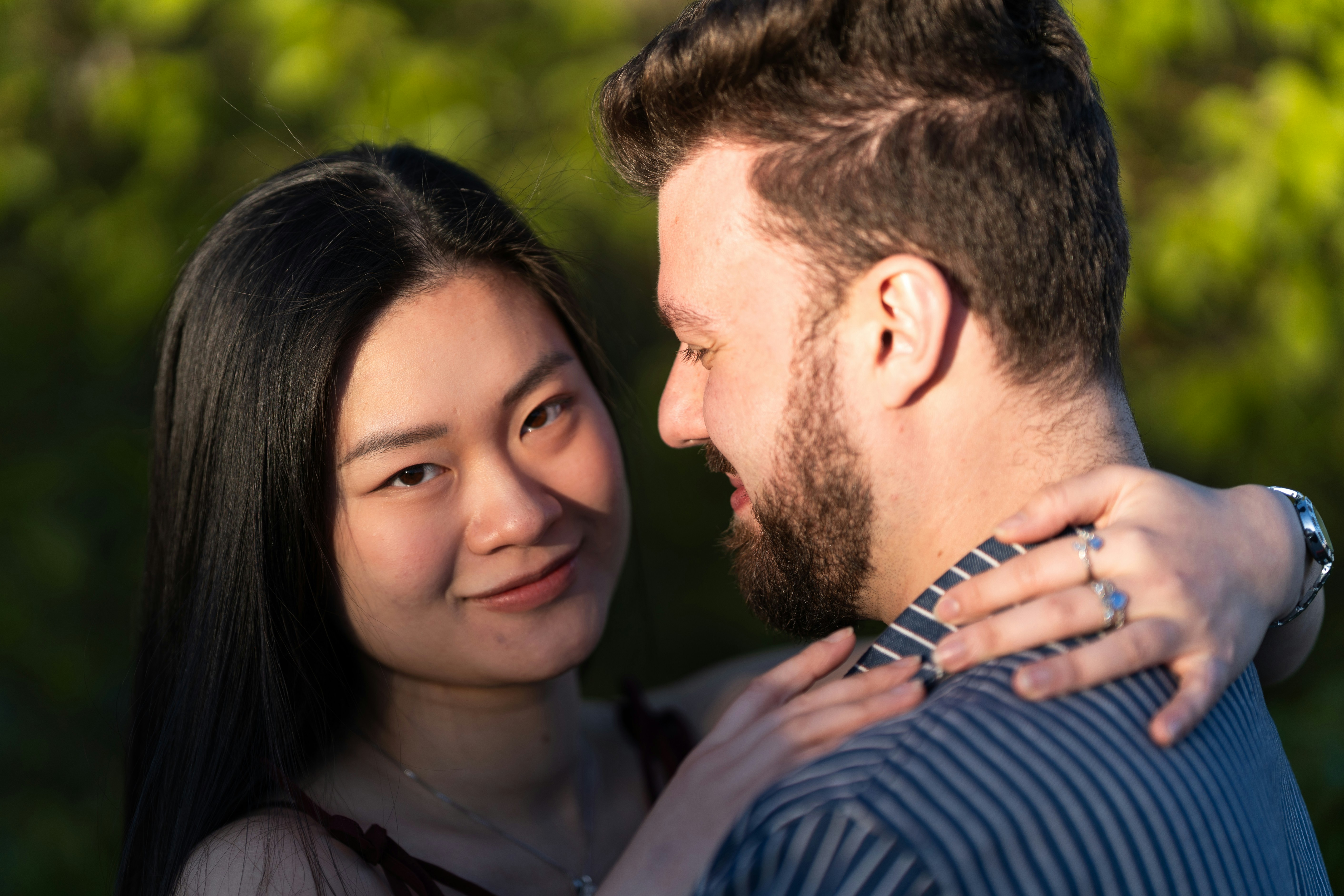 Una pareja abrazándose al aire libre con un fondo verde suave