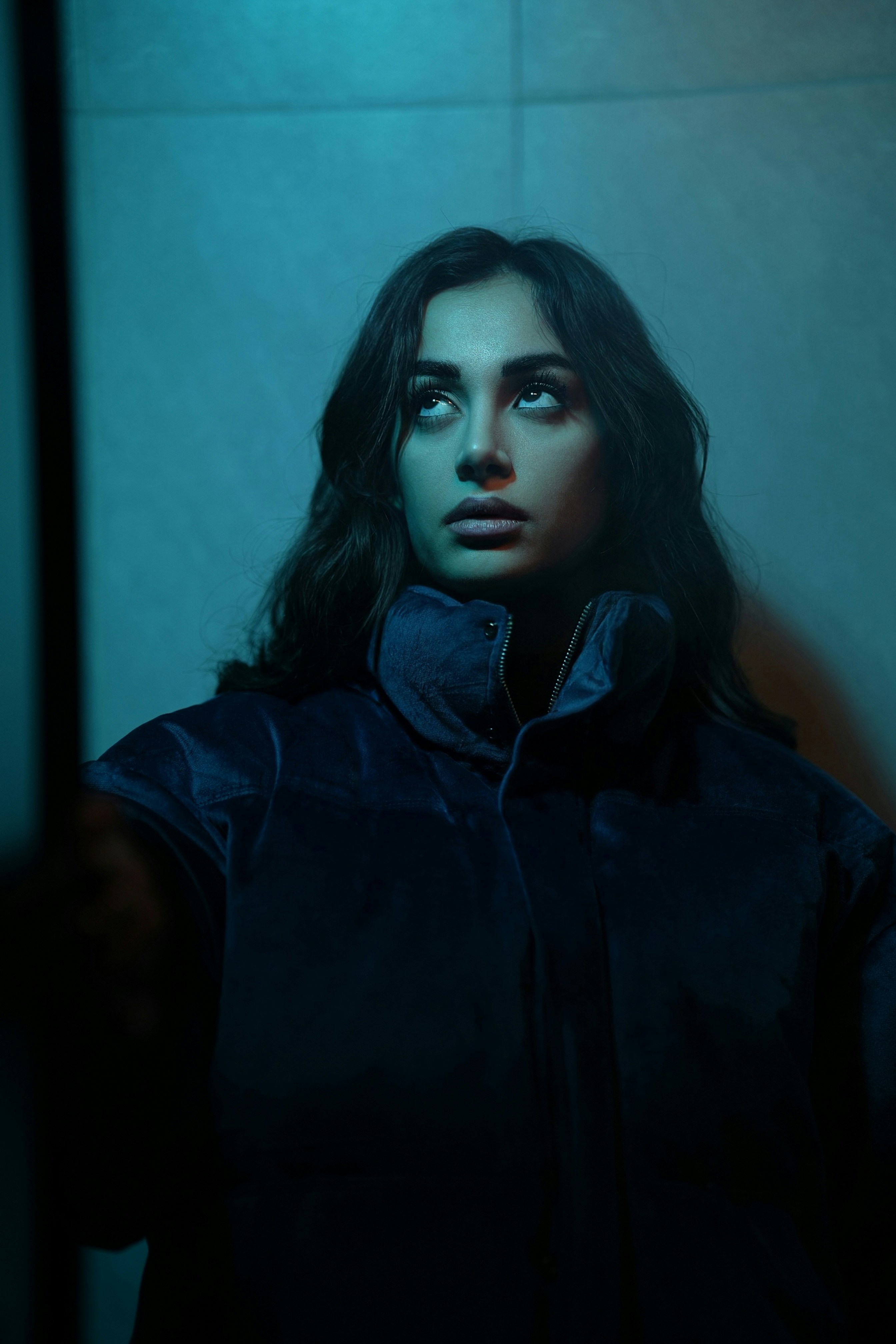 Donna che guarda in alto nella luce blu