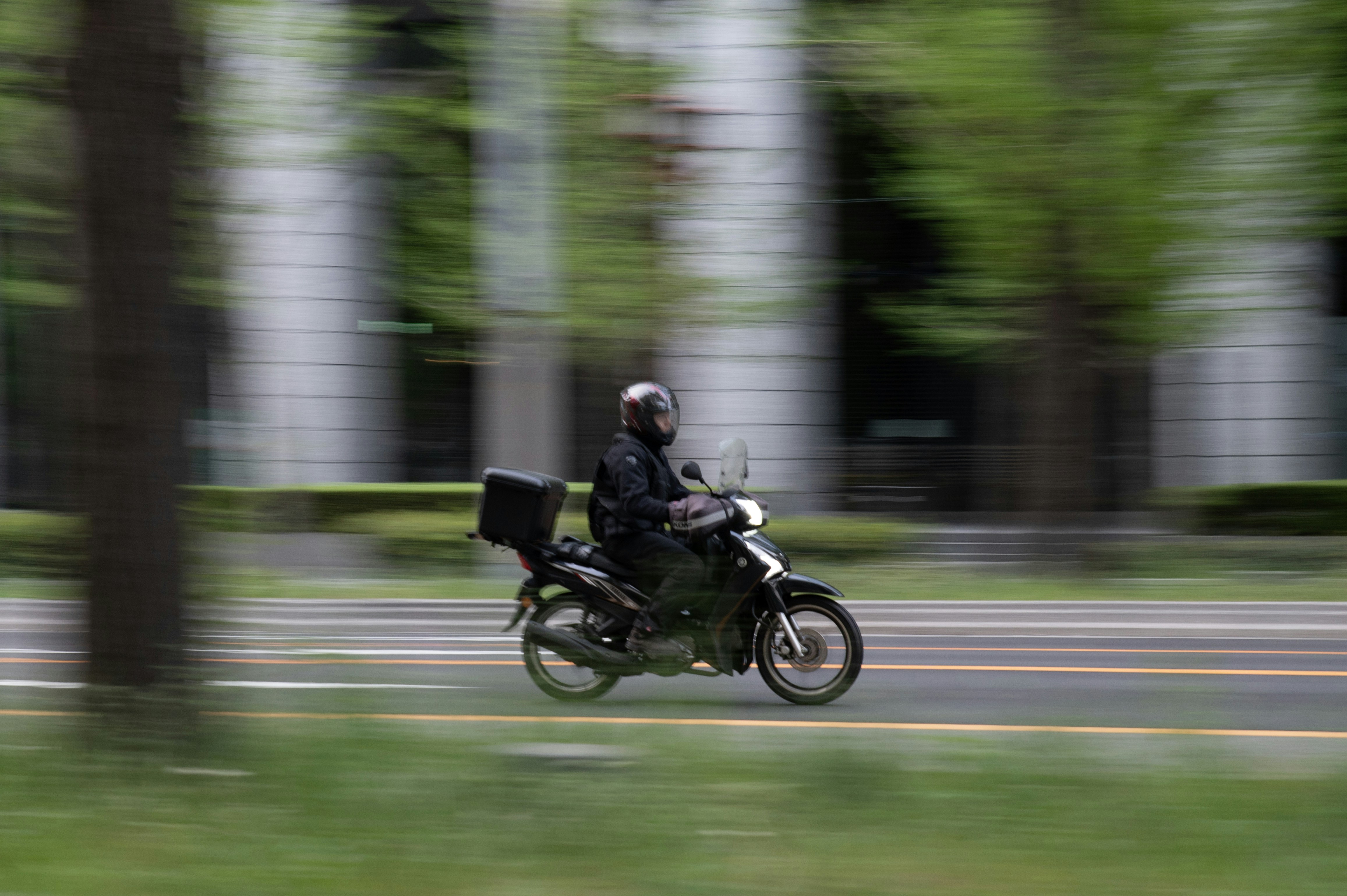 Una persona conduce una moto por una calle borrosa.