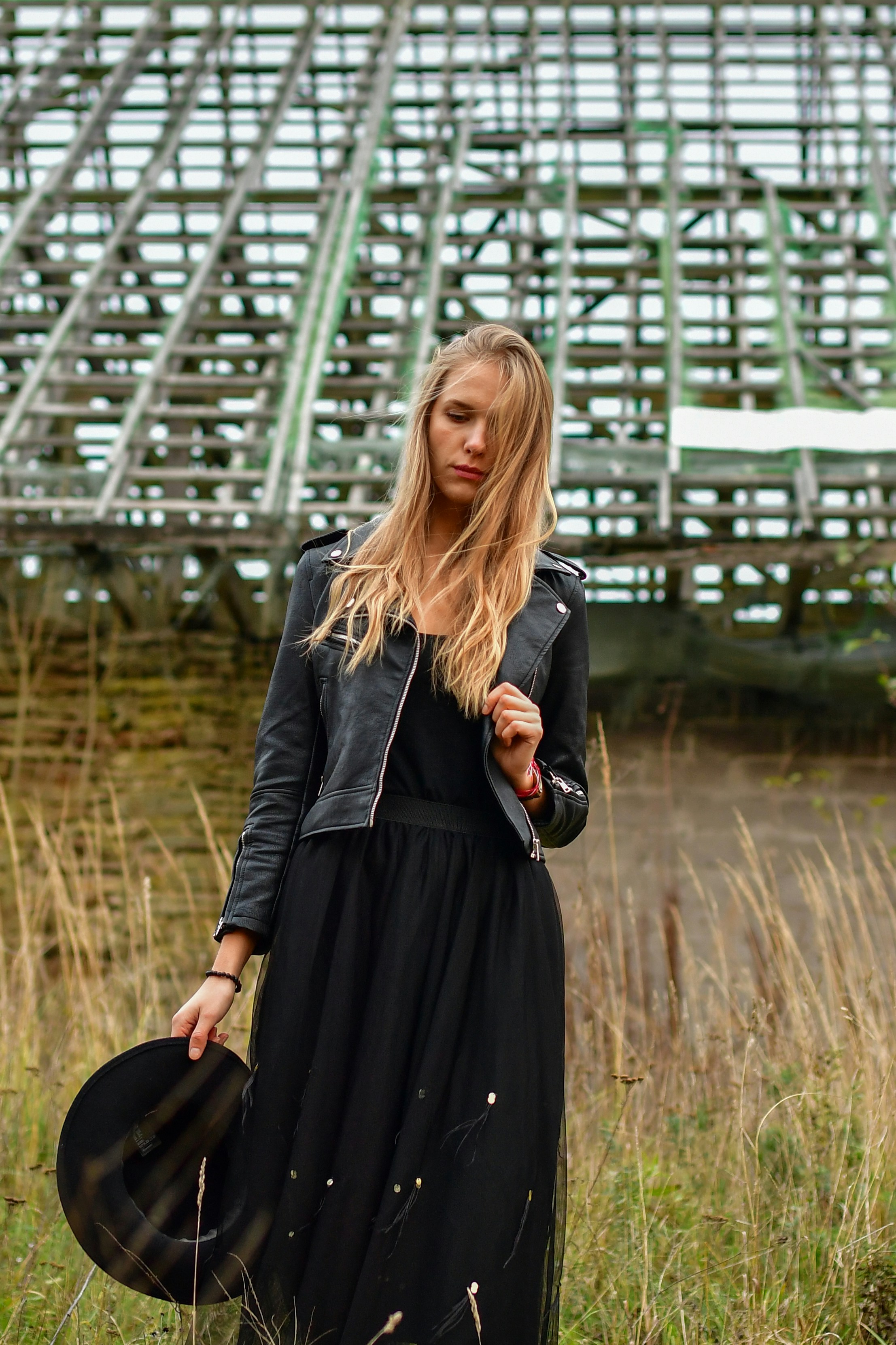 Junge Frau in schwarzem Kleid und Jacke mit Hut