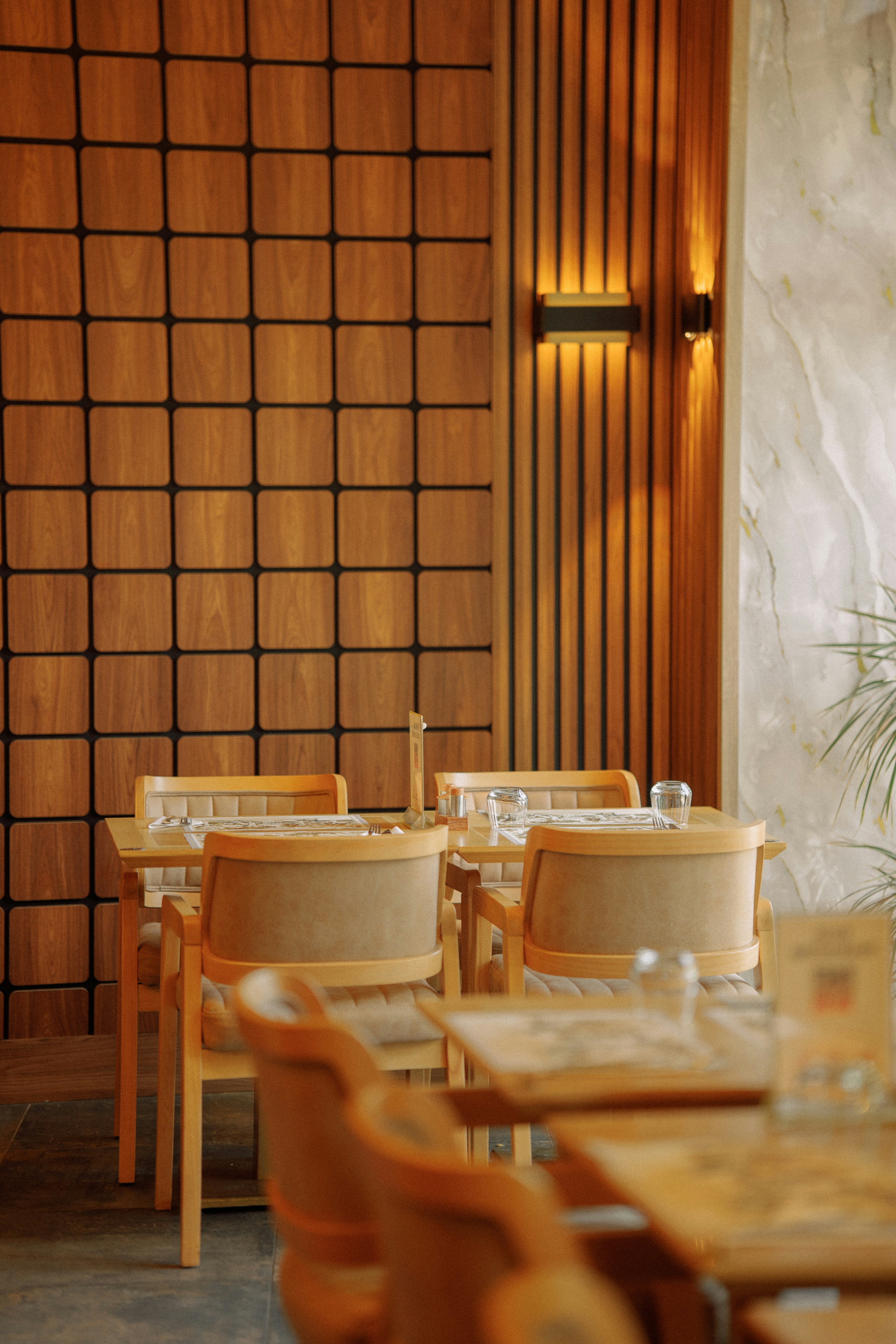 Restauranttische und Stühle mit warmen Holzakzenten.
