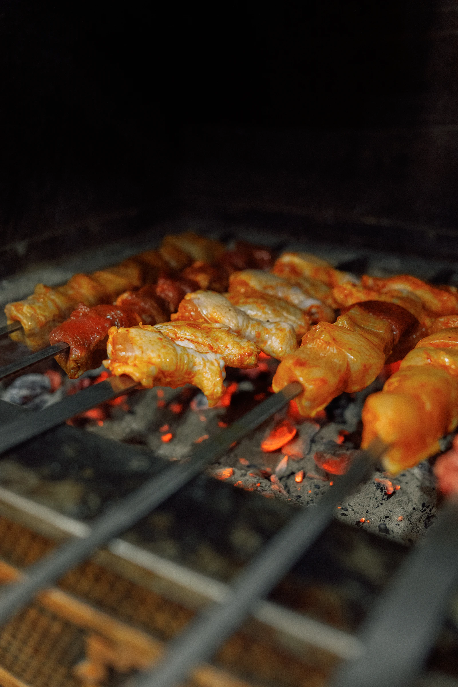 Meat skewers cooking over glowing coals
